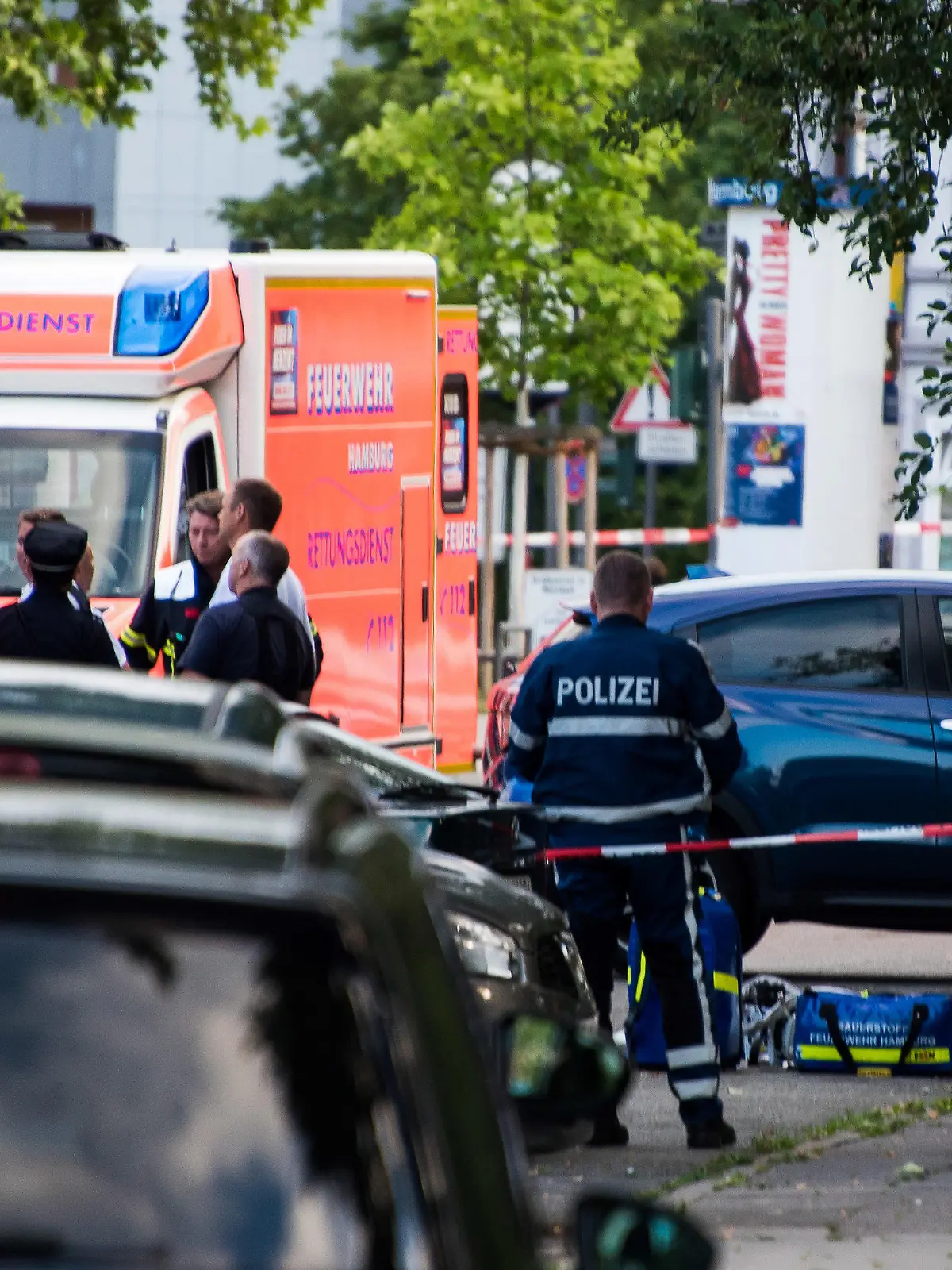 27.06.2019, Hamburg: Polizisten und Feuerwehrleute, stehen an einer abgesperrten Straße neben einem abgedeckten Körper. Ein Mann ist in Hamburg-Lohbrügge am erschossen worden. Einzelheiten oder Hintergründe konnte ein Sprecher des Lagezentrums der Polizei zunächst nicht nennen. Foto: Daniel Bockwoldt/dpa +++ dpa-Bildfunk +++