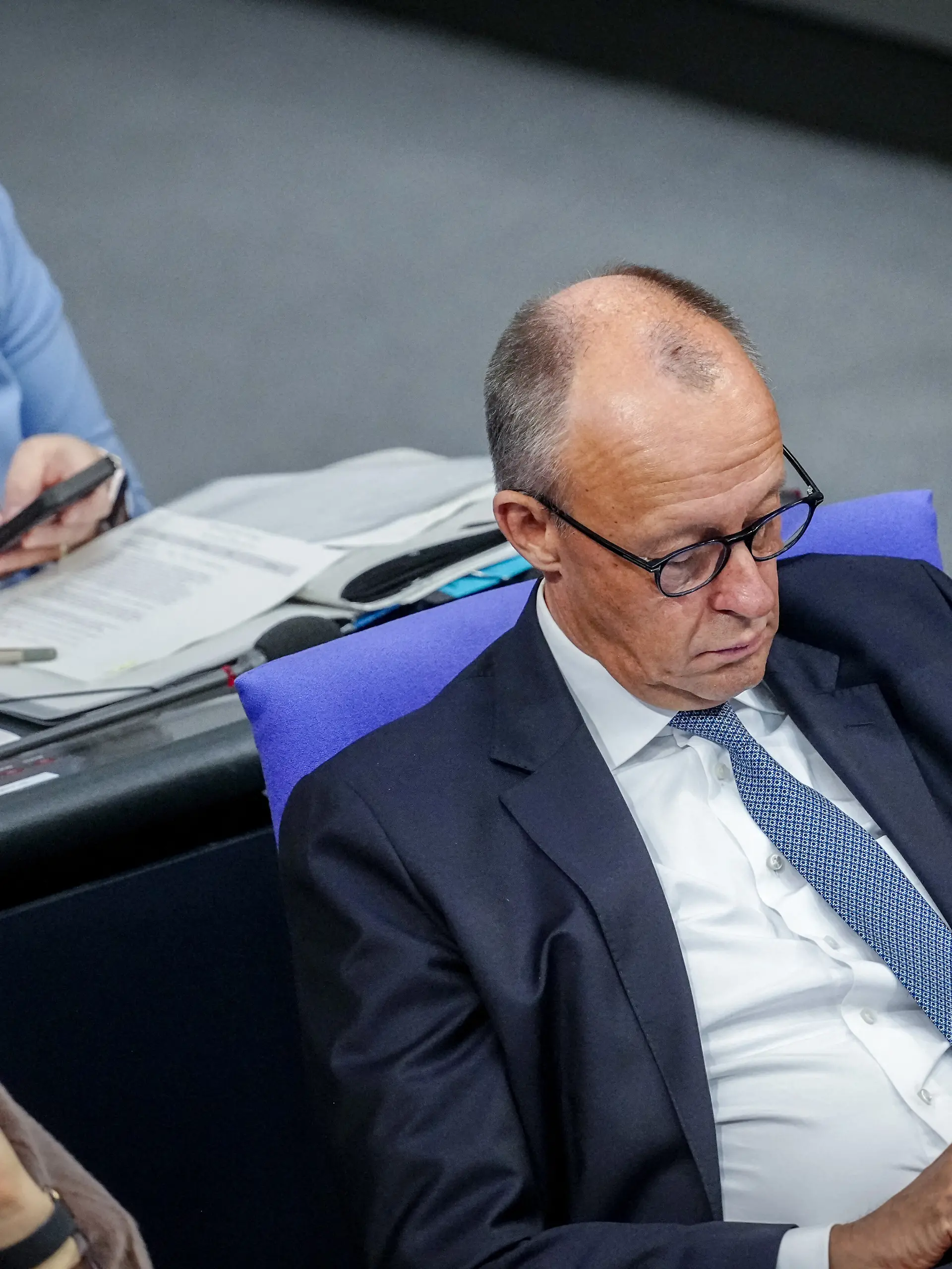 Nina Warken (CDU), Chefin des Bundeskanzleramts und Bundesministerin für besondere Aufgaben, und Bundeskanzler Friedrich Merz (CDU) schauen auf ihre Smartphones während der Sitzung des Bundestags.^Themen der Sitzung sind unter anderem Organspende und Befugnisse der deutschen Nachrichtendienste.