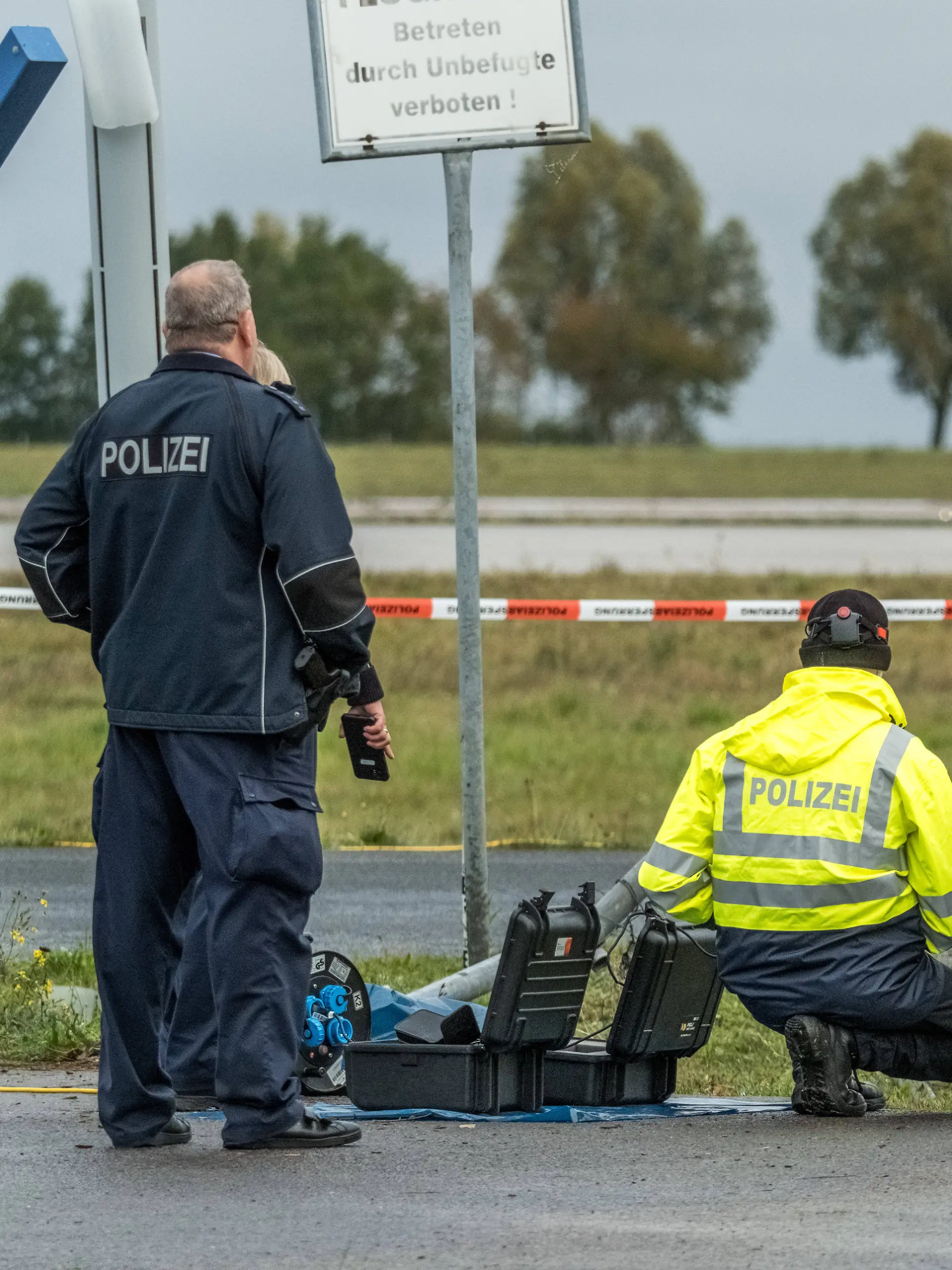 Ermittler sichern Spuren an einem Sicherheitszaun am Flughafen Leipzig/Halle, nachdem ein Auto den Zaun durchbrochen hat.