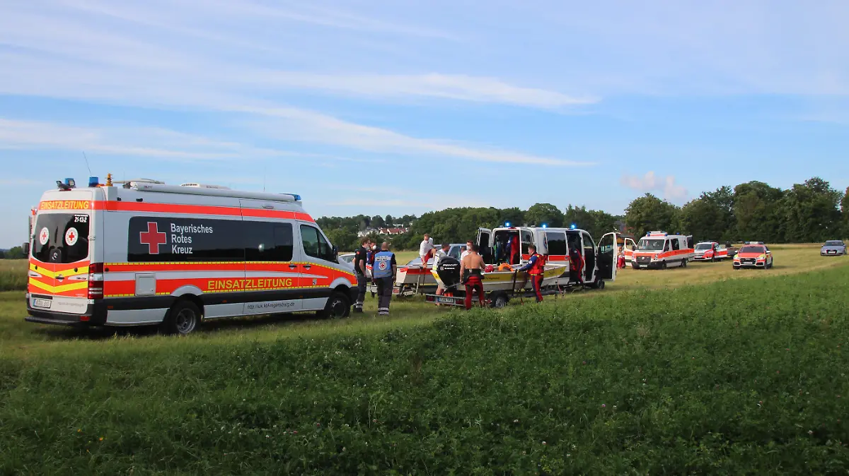 26.06.2021, Bayern, Zeitlarn: Rettungswagen stehen nahe der Einsatzstelle am Ufer des Flusses Regen. Nach einem Badeunfall in der Oberpfalz ist ein 53-Jähriger ums Leben gekommen. Zuvor war der sechs Jahre alte Sohn des Mannes beim Spielen in den Fluss Regen gefallen, wie die Polizei am Sonntag mitteilte. Der Vater und zwei weitere Bekannte seien im Anschluss hinterhergesprungen, um dem Jungen zu helfen. Foto: --/vifogra /dpa +++ dpa-Bildfunk +++