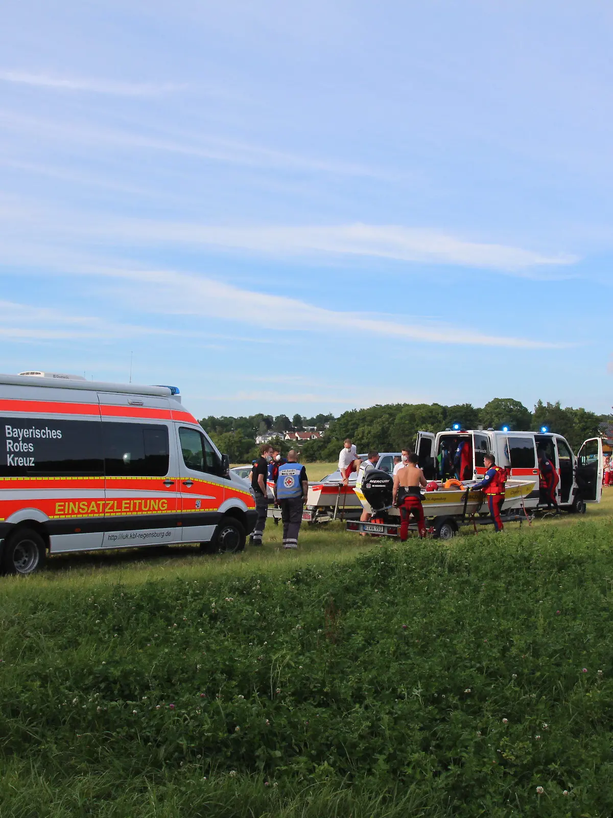 26.06.2021, Bayern, Zeitlarn: Rettungswagen stehen nahe der Einsatzstelle am Ufer des Flusses Regen. Nach einem Badeunfall in der Oberpfalz ist ein 53-Jähriger ums Leben gekommen. Zuvor war der sechs Jahre alte Sohn des Mannes beim Spielen in den Fluss Regen gefallen, wie die Polizei am Sonntag mitteilte. Der Vater und zwei weitere Bekannte seien im Anschluss hinterhergesprungen, um dem Jungen zu helfen. Foto: --/vifogra /dpa +++ dpa-Bildfunk +++