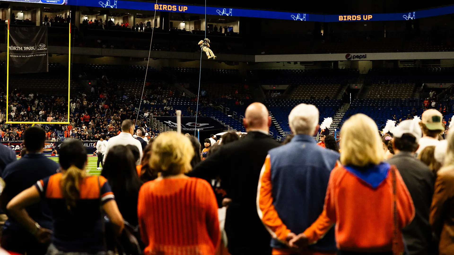 17.10.2026, USA, San Antonino: Ein Soldat seilt sich nach einem Zwischenfall während einer Vorführung vor dem NCAA-College-Football-Spiel zwischen den Roadrunners der University of Texas at San Antonio und den Navy Midshipmen im Alamodome sicher vom Dach des Alamodome ab. Foto: Joe Nogalski/ZUMA Press Wire/dpa +++ dpa-Bildfunk +++