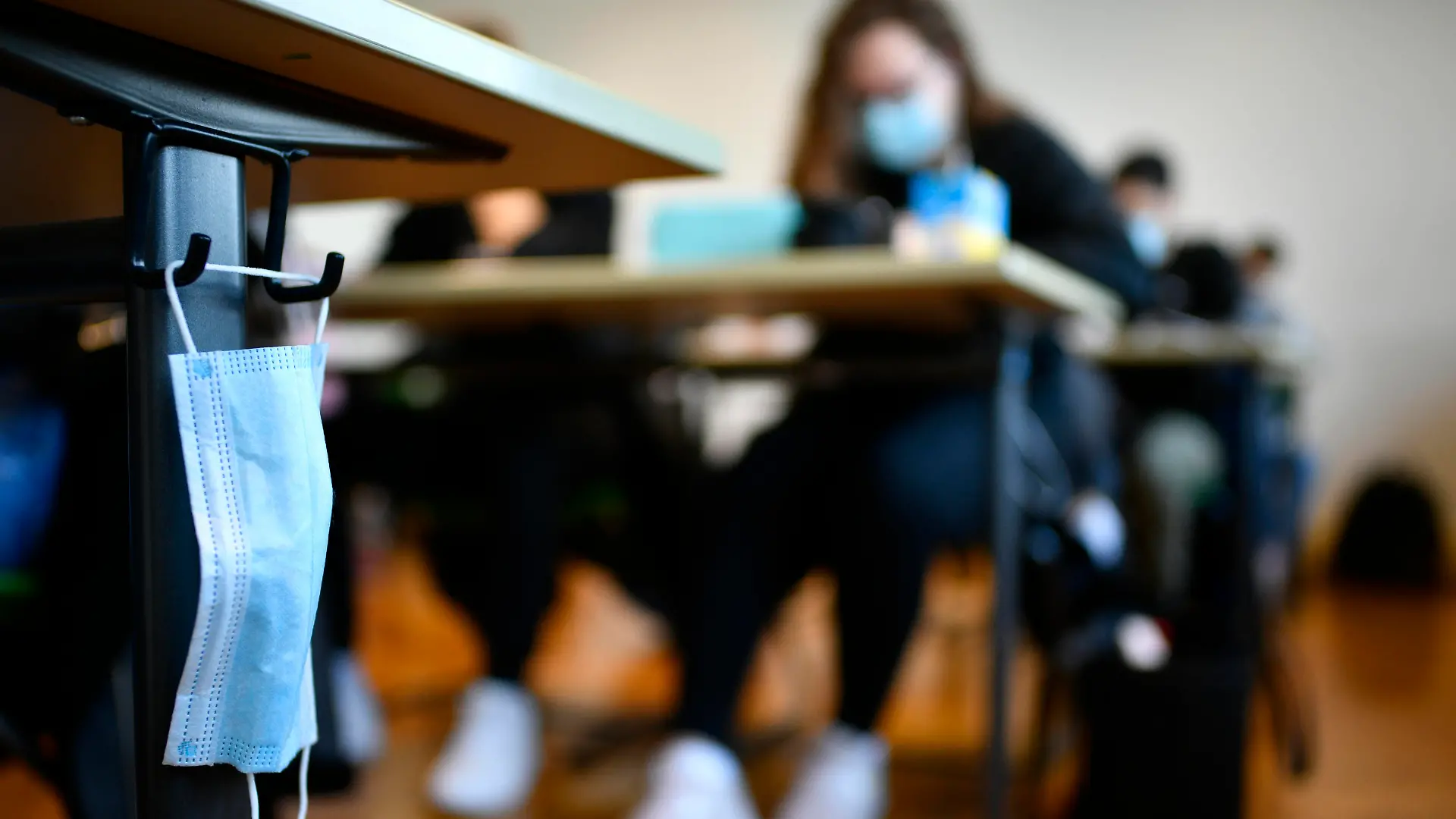 Mundschutzmaske hängt an Schülertisch, Präsenzunterricht, Corona-Krise, Stuttgart, Baden-Württemberg, Deutschland Coronavirus *** Mouth mask hangs at students desk, attendance lessons, corona crisis, Stuttgart, Baden Württemberg, Germany Coronavirus