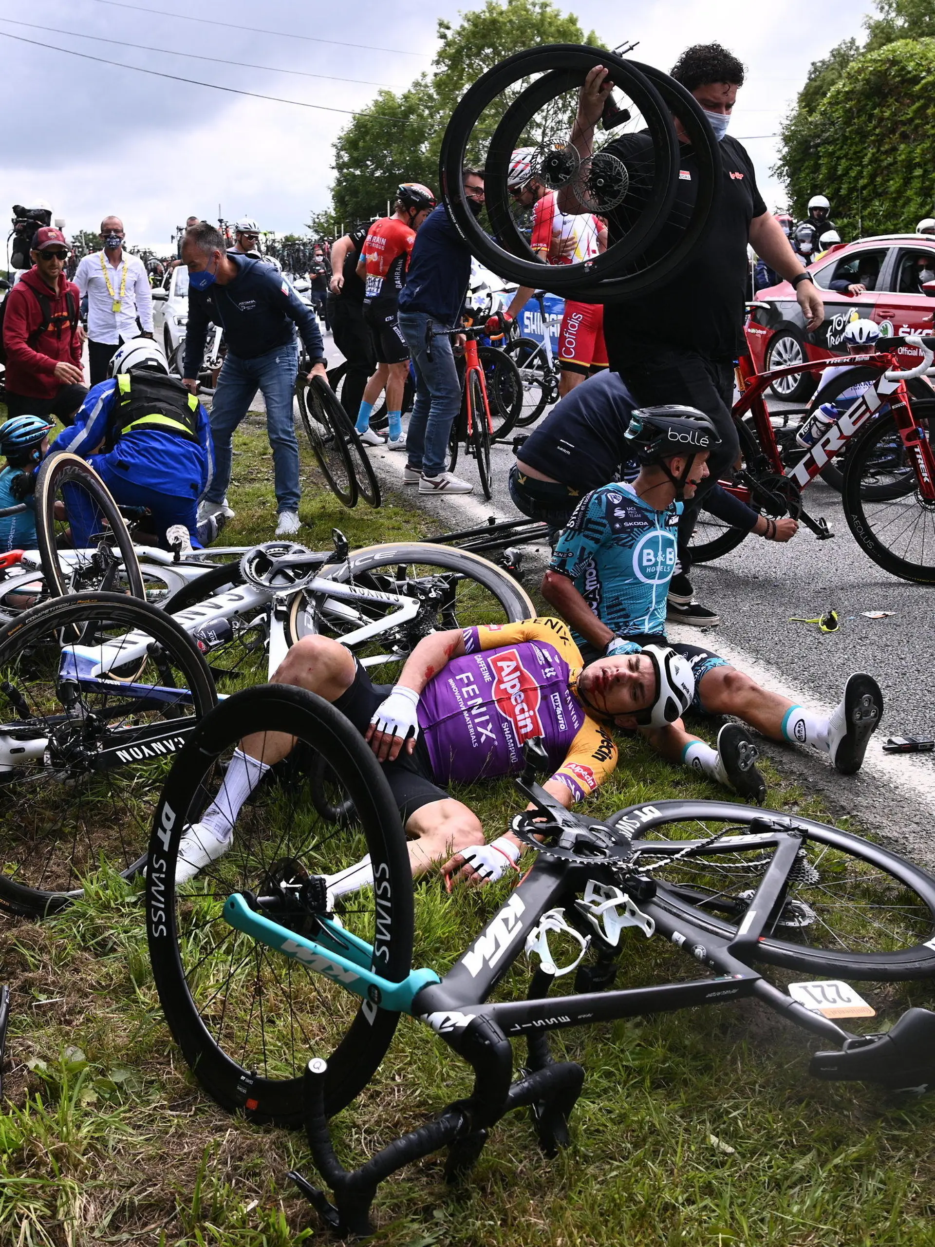 26.06.2021, Frankreich, Landerneau: Radsport: UCI WorldTour - Tour de France, Brest - Landerneau (197,80 km), 1. Etappe.  Ein Fahrer von Alpecin-Fenix (l) und  Bryan Coquard (r) aus Frankreich von BB Hotels P/B KTM liegen nach einem Sturz auf dem Boden. Foto: Pool Anne-Christine Poujoulat/BELGA/dpa +++ dpa-Bildfunk +++