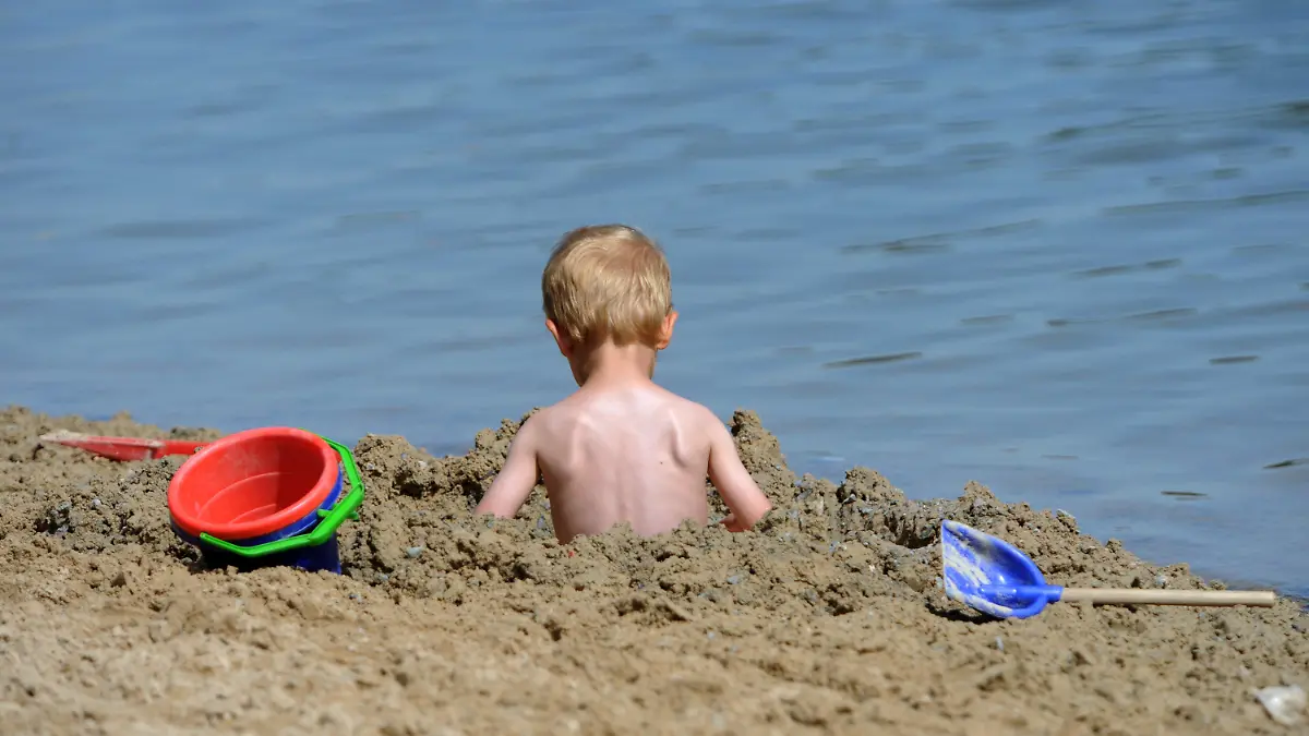 Ein kleines Kind sitzt am Freitag (17.08.2012) am Ufer des Twistesees bei Bad Arolsen (Landkreis Waldeck-Frankenberg) in einem Sandloch. Abkühlung wird sehr gefragt sein an diesem Wochenende, für das Rekordtemperaturen vorhergesagt wurden. Foto: Uwe Zucchi dpa/lhe  +++(c) dpa - Bildfunk+++