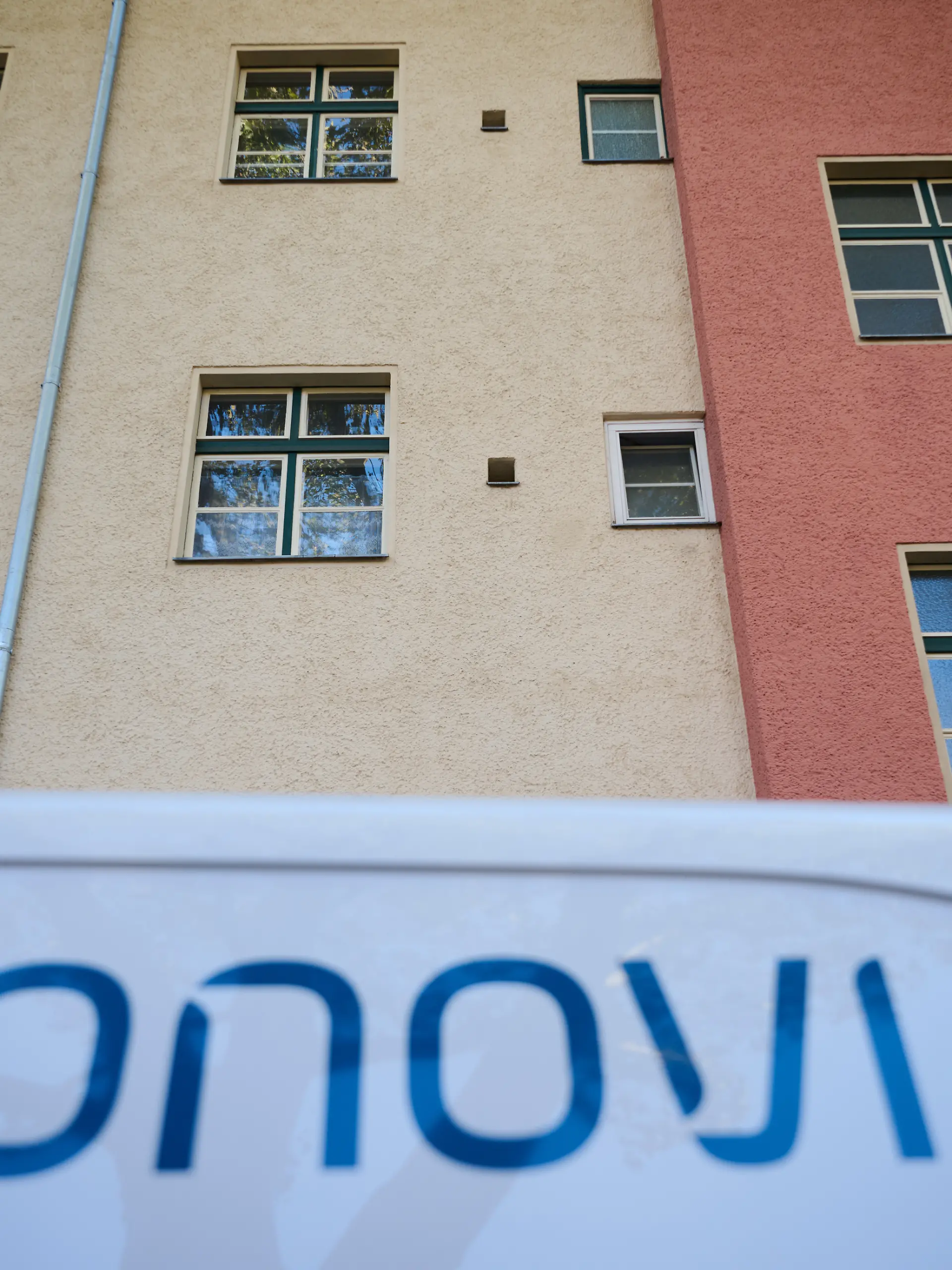 Ein Kastenwagen mit dem Schriftzug von Vonovia steht vor einem Mehrfamilienhaus.