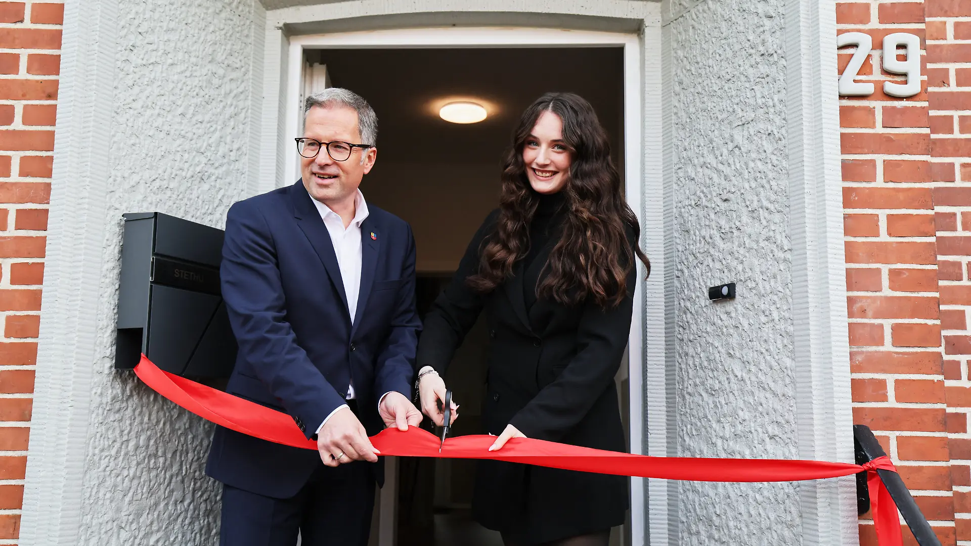 19.10.2026, Niedersachsen, Stade: Kiara Lindner, Gesellschafterin und Geschäftsführerin Stethu GmbH, und Kai Seefried (CDU, l), Landrat Kreis Stade, durchschneiden ein symbolisches Band bei Wiedereröffnung des Mutter-Kind-Hauses der Stethu in Stade. Nach der Gewalttat mit 6 Toten am 29. Juni 2026, drei Mitarbeiterinnen und Mitarbeiter des Jugendamtes Hannover sowie drei Beschäftigte in der Mutter-Kind-Einrichtung, wurde das Haus am Montag wieder eröffnet. Foto: Christian Charisius/dpa +++ dpa-Bildfunk +++