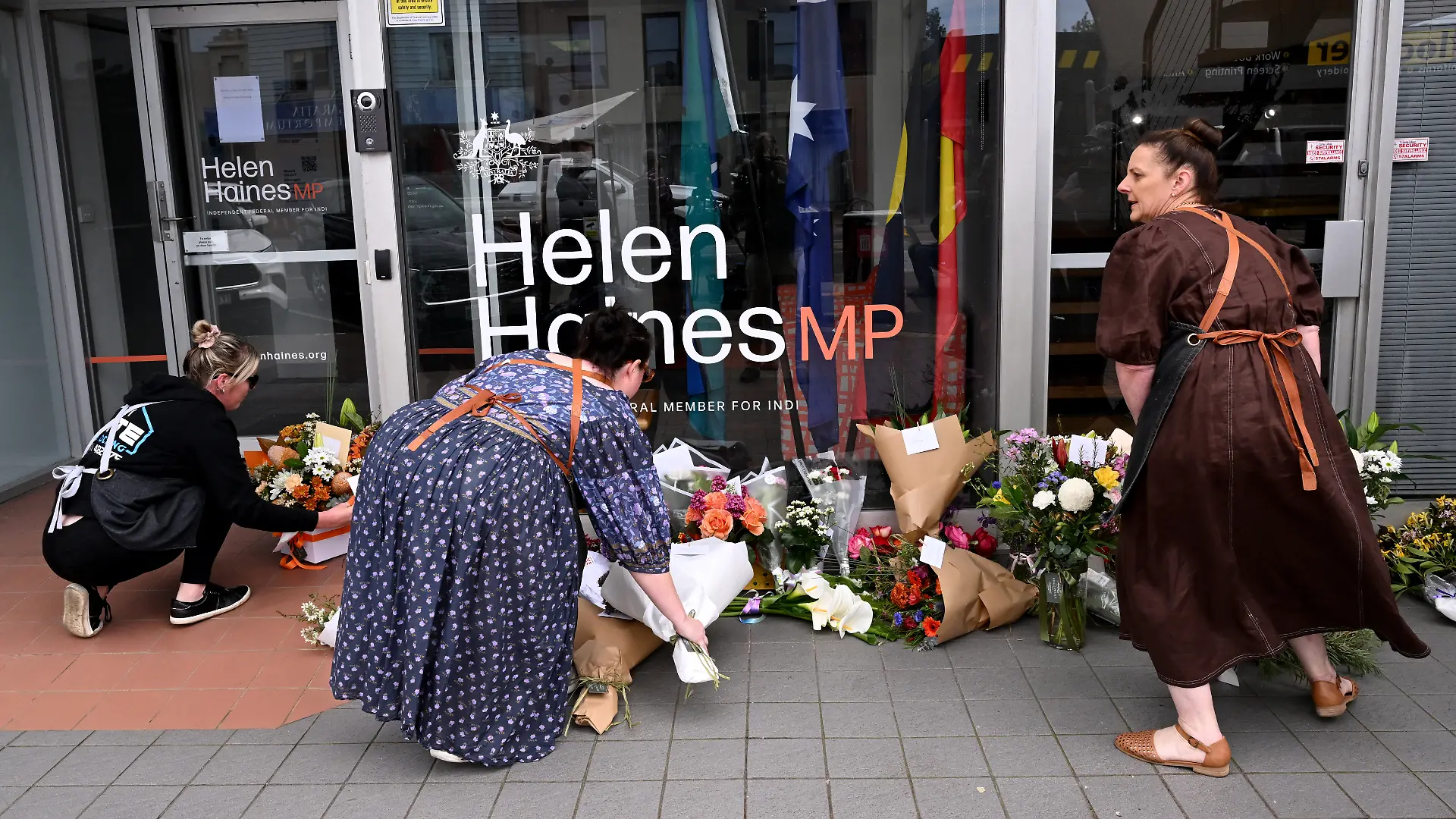 People lay flowers outside the office of Australian politician Helen Haines in the northern regional city of Wangaratta, some 250 kilometres north-east of Melbourne on October 20, 2026. Australian independent lawmaker Helen Haines underwent surgery overnight but remains in a critical condition after being struck deliberately by a car in an attack, Prime Minister Anthony Albanese said on October 20. (Photo by William WEST / AFP)