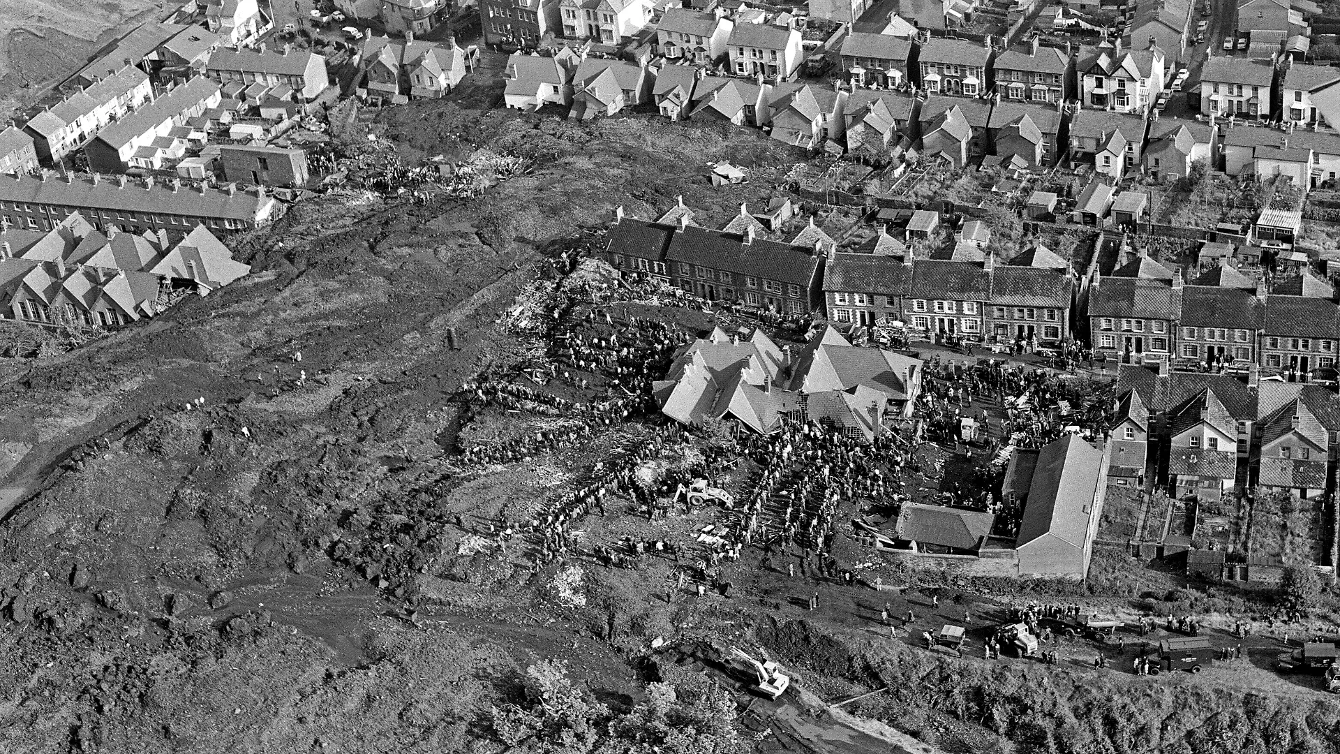 Eine Luftaufnahme vom 21. Oktober 1966 zeigt das Ausmaß der Katastrophe von Aberfan: Die Schlammlawine zerstörte eine Schule und mehrere Häuser. Helfer suchen nach Verschütteten.