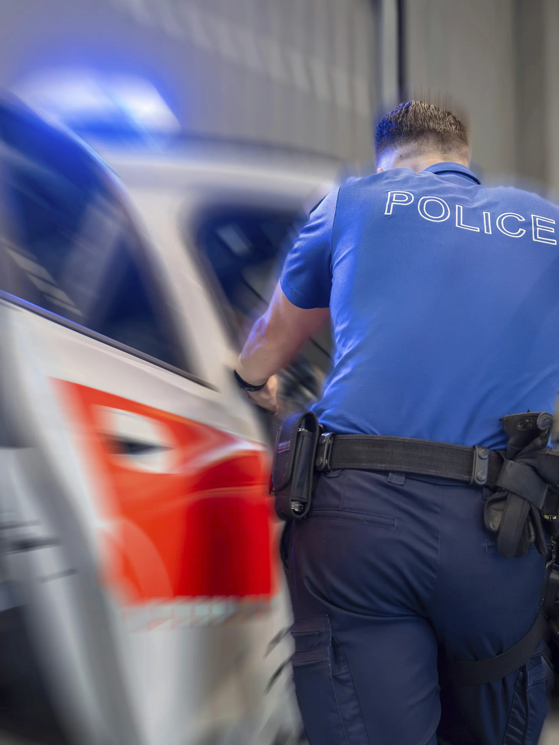 Ein Schweizer Polizist am Streifenwagen (Symbolbild)