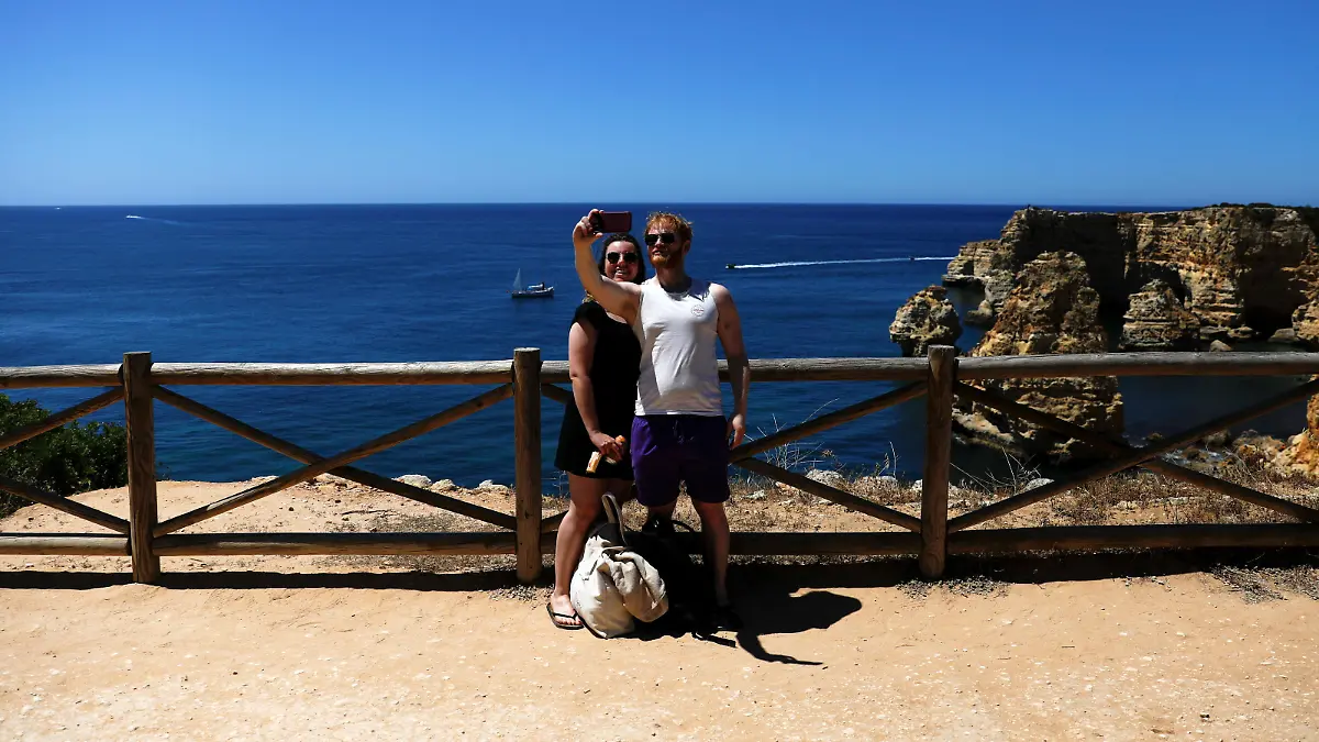 People take photos at Marinha beach amid the coronavirus disease (COVID-19) pandemic, in Albufeira, Portugal, June 4, 2021. REUTERS/Pedro Nunes