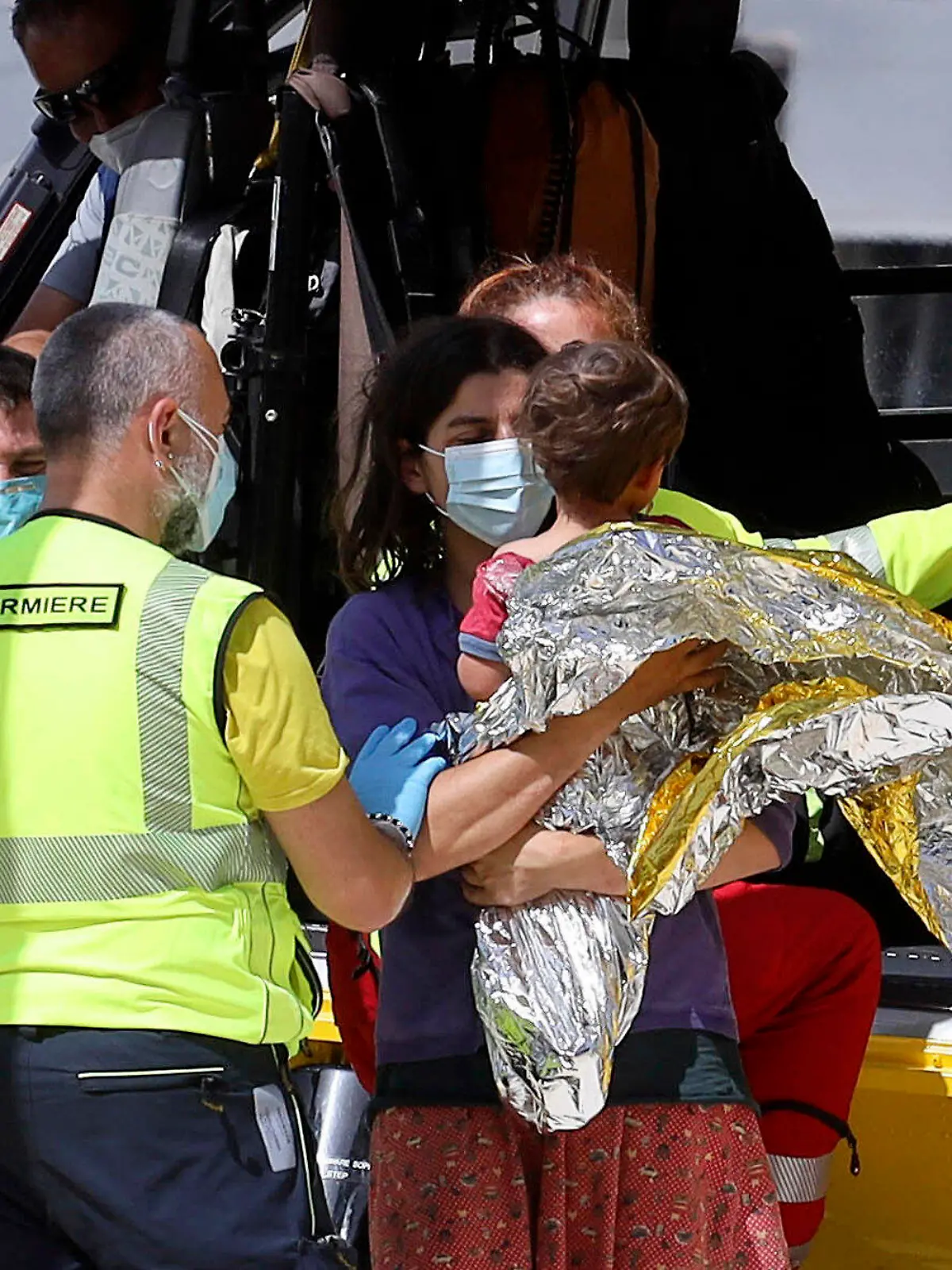 21-month-old Nicola Tanturli is carried by his mother after they were transported by helicopter to Careggi hospital in Florence, Italy, Wednesday, June 23, 2021. The child was found alive Wednesday in the bottom of a ravine after spending two nights alone in the woods near his home in Tuscany. ( Giuseppe CabrasLaPresse via AP)