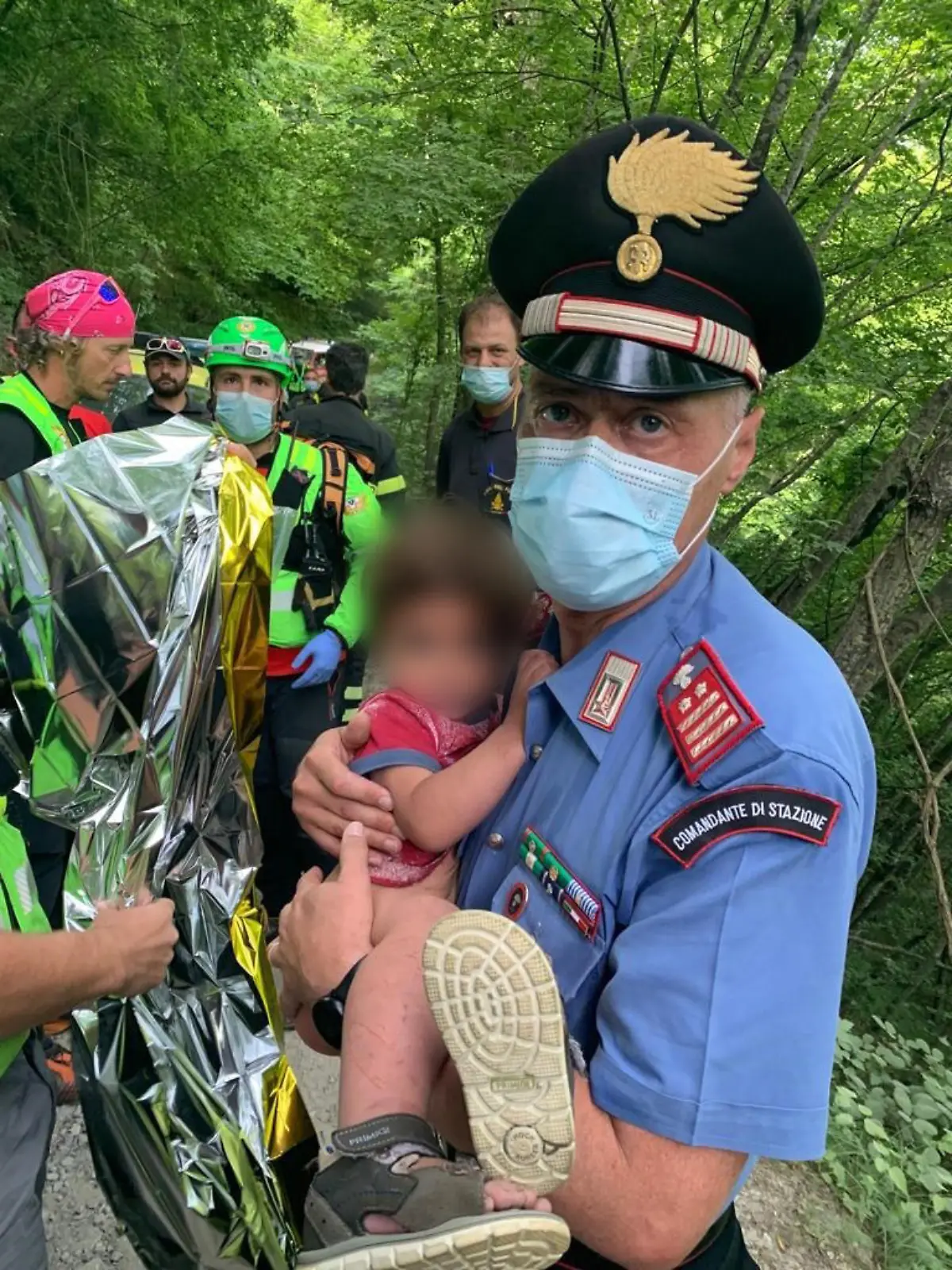 HANDOUT - 23.06.2021, Italien, Palazzuolo sul Senio: Ein Carabinieri hält den kleinen 21 Monate alten Jungen im Arm, der nachts in Palazzuolo sul Senio im Apennin-Gebirge in der Toskana von zu Hause ausgebüxt war und einen großen Sucheinsatz der Rettungskräfte ausgelöst hatte. (zu dpa "Junge nachts ins Gebirge ausgebüxt - stundenlange Suche in Italien") Foto: Carabinieri/dpa - ACHTUNG: Kind wurde aus rechtlichen Gründen gepixelt. Nur zur redaktionellen Verwendung im Zusammenhang mit der aktuellen Berichterstattung. +++ dpa-Bildfunk +++