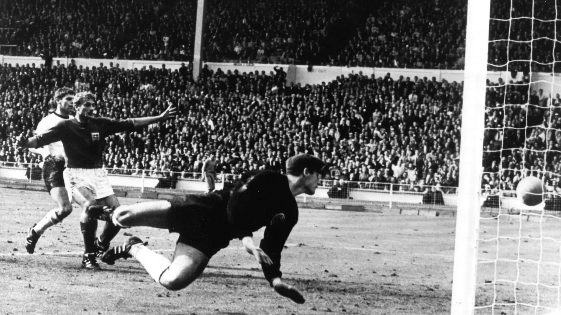 ARCHIV - Tor oder nicht Tor im Finale Deutschland gegen England bei der Fußball-WM 1966 am 30. Juli im Londoner Wembley-Stadion. Der vom englischen Stürmer Geoff Hurst (nicht im Bild) geschossene Ball knallt von der Latte auf den Boden. Der deutsche Torhüter Hans Tilkowski (vorn) schaut sich im Hechten um, Abwehrspieler Wolfgang Weber (l) und der jubelnde englische Stürmer Roger Hunt schauen zu (Archivfoto vom 30.07.1966). Das nicht gegebene ukrainische Tor im Spiel der Fußball-EM gegen England erregte bei der 0:1-Niederlage am Dienstagabend die ausgeschiedenen Gastgeber. Seit dem Wembley-Tor im WM-Finale 1966 hat es mehrere spektakuläre Fälle gegeben, in denen Treffer zu Unrecht anerkannt wurden oder nicht zählten. Foto: dpa (zu dpa 0015 vom 20.06.2012)  +++(c) dpa - Bildfunk+++