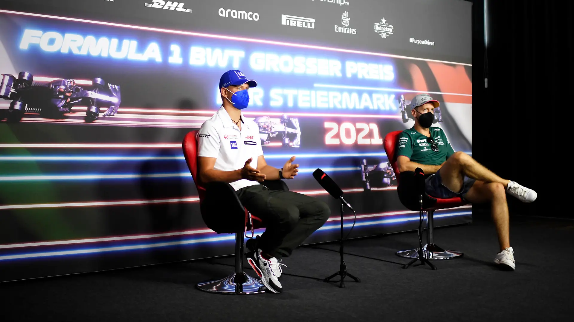 SPIELBERG, AUSTRIA - JUNE 24: Sebastian Vettel of Germany and Aston Martin F1 Team and Mick Schumacher of Germany and Haas F1 talk in the Drivers Press Conference during previews ahead of the F1 Grand Prix of Styria at Red Bull Ring on June 24, 2021 in Spielberg, Austria. (Photo by Christian Bruna - Pool/Getty Images)