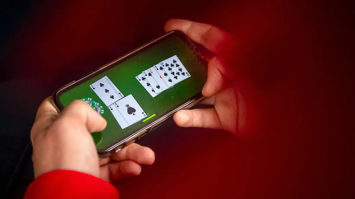 23.06.2021, Bremen: ILLUSTRATION - Auf einem Smartphone wird ein Online-Spiel gespielt. Mit dem neuen Glücksspielstaatsvertrag der am 1. Juli in Kraft tritt, werden bisher verbotene virtuelle Automatenspiele im Internet sowie Online-Casinos mit Poker oder Roulette erlaubt. Foto: Sina Schuldt/dpa +++ dpa-Bildfunk +++