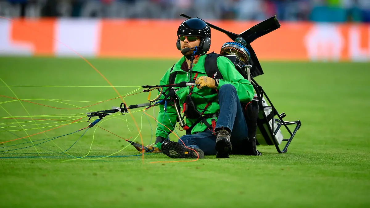 15.06.2021, Munich: Fußball: EM, Frankreich - Deutschland, Vorrunde, Gruppe F, 1. Spieltag in der EM-Arena München. Ein Aktivist, der zu Beginn des Spiel mit einem Gleitschirm im Stadion gelandet war, sitzt auf dem Rasen. Important: For editorial news reporting purposes only. Not used for commercial or marketing purposes without prior written approval of UEFA. Images must appear as still images and must not emulate match action video footage. Photographs published in online publications (whether via the Internet or otherwise) shall have an interval of at least 20 seconds between the posting. Foto: Matthias Hangst/Getty Pool/dpa +++ dpa-Bildfunk +++