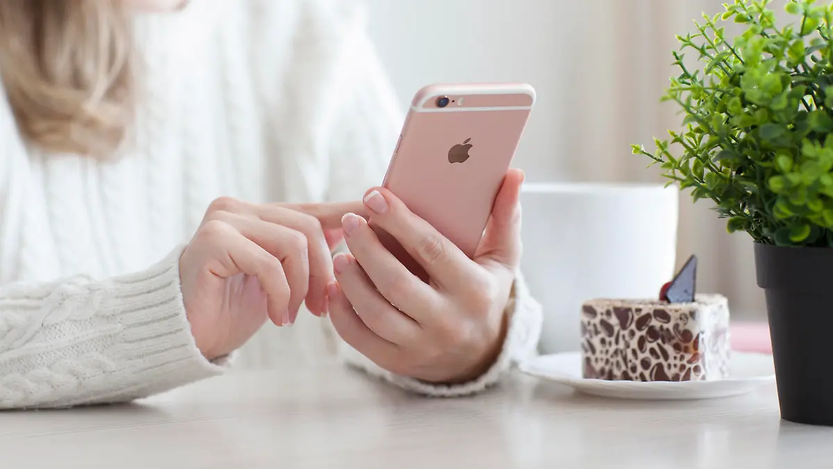 Alushta, Russia - October 25, 2015: Woman holding in the hand iPhone 6 S Rose Gold in cafe. iPhone 6S was created and developed by the Apple inc.