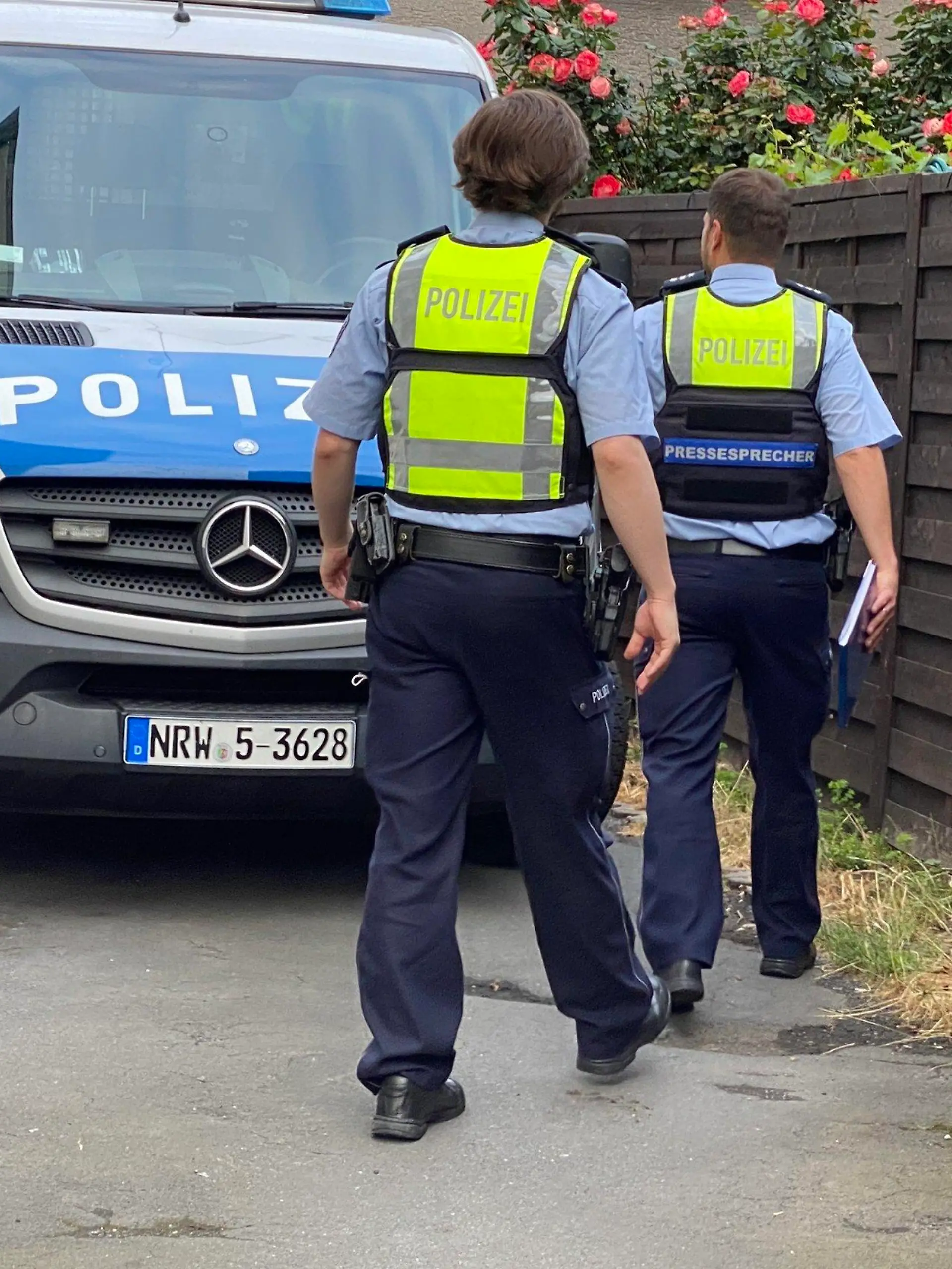 24.06.2021, Nordrhein-Westfalen, Bochum: Einsatzkräfte gehen bei einer Razzia zu einem Polizeiwagen. Bei einer Clan-Razzia im Ruhrgebiet haben Einsatzkräfte am frühen Donnerstagmorgen 21 Objekte in Dortmund und angrenzenden Städten durchsucht. Es gehe um bandenmäßigen Handel mit Kokain im zweistelligen Kilogramm-Bereich und Verstöße gegen das Waffengesetz im Bereich der Organisierten Kriminalität, sagte eine Sprecherin der federführenden Polizei Dortmund. (zu dpa "Razzia gegen Miri-Clan in Dortmund und weiteren Städten") Foto: Justin Brosch/dpa +++ dpa-Bildfunk +++