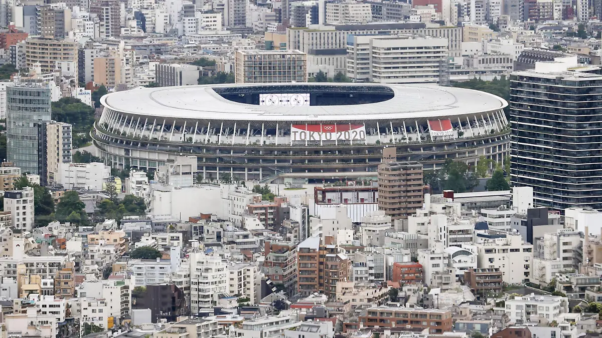 22.06.2021, Japan, Tokio: Ein Banner verkündet auf dem Nationalstadion, einem Austragungsort der Olympischen Spiele und Paralympics in Tokio, unter dem Zeichen der Olympischen Ringe "Tokio 2020". Die Olympischen Spiele 2020 sind die aktuellen Olympischen Sommerspiele und sollen corona-bedingt vom 23. Juli bis zum 8. August 2021 in Tokio stattfinden. Foto: ---/kyodo/dpa +++ dpa-Bildfunk +++