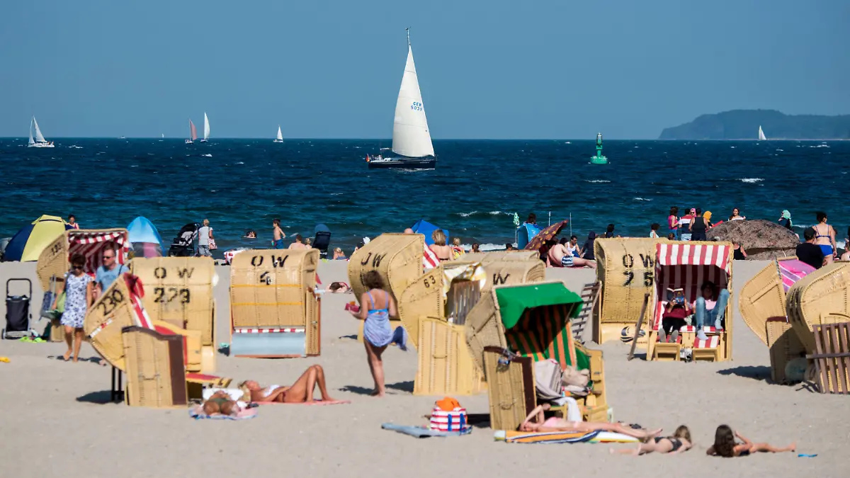 24.08.2019, Schleswig-Holstein, Lübeck-Travemünde: Zahlreiche Menschen genießen in Strandkörben am Strand der Ostsee das gute Wetter. Foto: Daniel Bockwoldt/dpa +++ dpa-Bildfunk +++