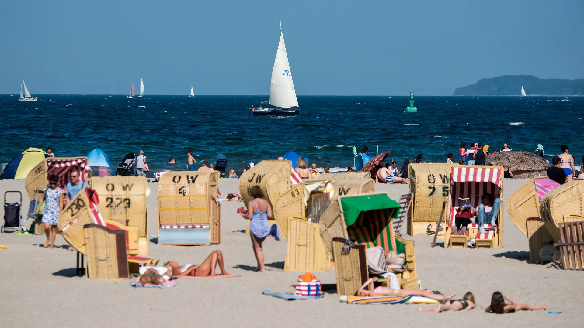 24.08.2019, Schleswig-Holstein, Lübeck-Travemünde: Zahlreiche Menschen genießen in Strandkörben am Strand der Ostsee das gute Wetter. Foto: Daniel Bockwoldt/dpa +++ dpa-Bildfunk +++