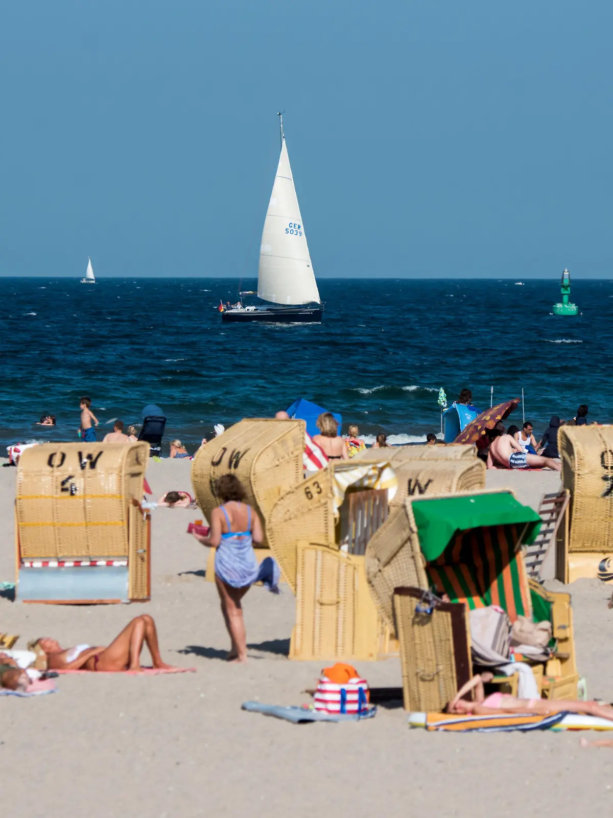 24.08.2019, Schleswig-Holstein, Lübeck-Travemünde: Zahlreiche Menschen genießen in Strandkörben am Strand der Ostsee das gute Wetter. Foto: Daniel Bockwoldt/dpa +++ dpa-Bildfunk +++