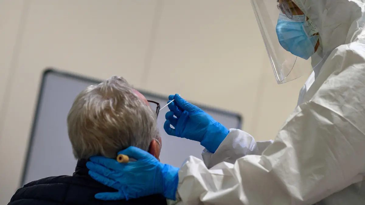 12.01.2021, Sachsen-Anhalt, Magdeburg: Ein Mitarbeiter des Universitätsklinikums Magdeburg führt bei einem Mann einen Antigentest auf das Coronavirus durch. In dem Testzentrum wird kostenlos auf das Coroavirus getestet. Dabei wird neben dem herkömmlichen Antigen-Schnelltest auch ein Spuckspeicheltest verwendet. Der Spuckspeicheltest wird vom Serumwerk in Bernburg hergestellt und ist in Deutschland mit einer 94-prozentigen Sensitivität zugelassen worden. Durch die parallele Testung soll dieser Test nun weiter validiert werden. Er liefert nach zehn Minuten ein Ergebnis. Sollte eine Person positiv getestet werden, folgt noch ein PCR-Test, um das Ergebnis weiter abzusichern. Foto: Klaus-Dietmar Gabbert/dpa-Zentralbild/dpa +++ dpa-Bildfunk +++