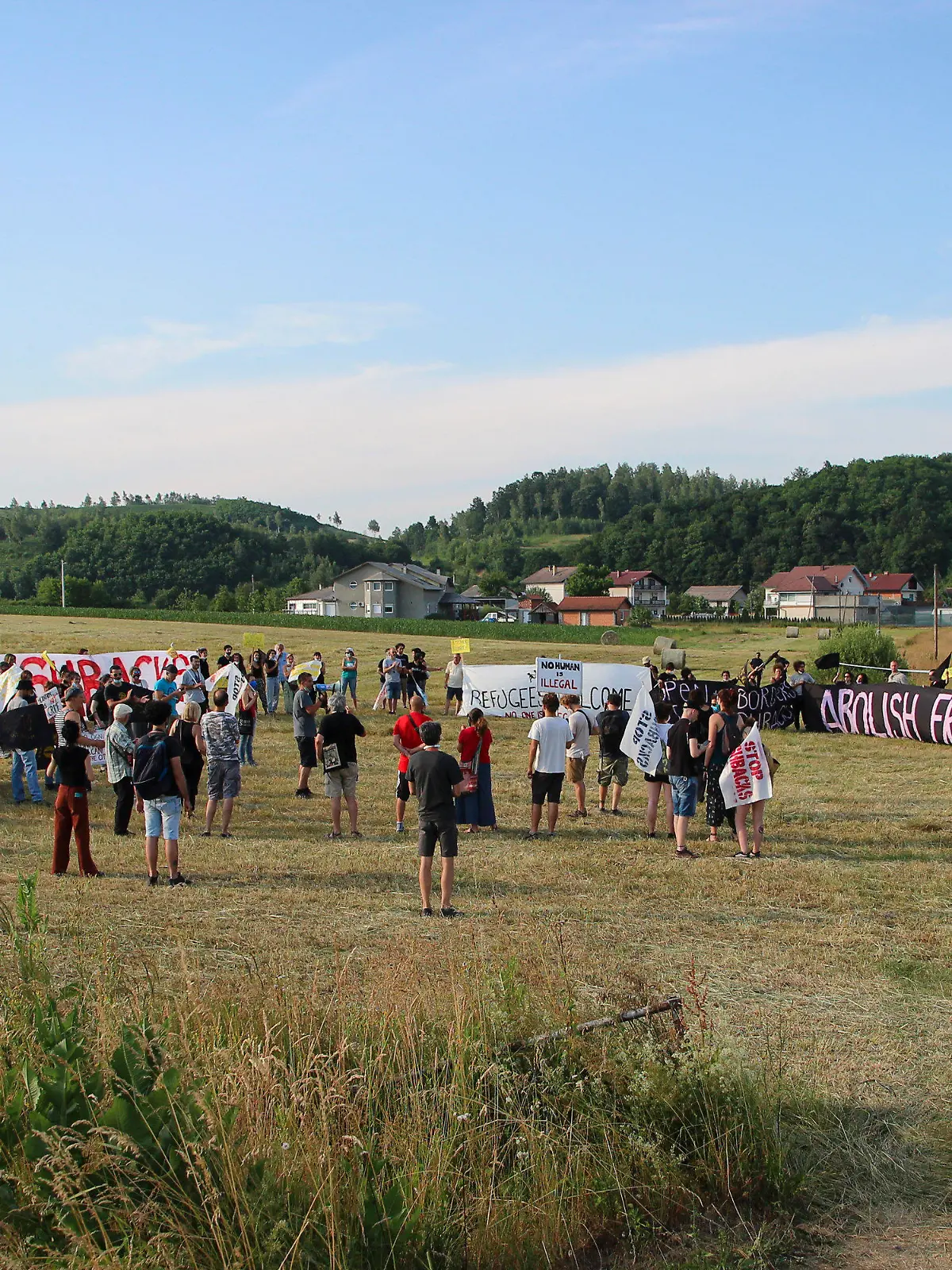 People take part in a protest against the violent pushbacks of migrants, allegedly conducted by Croatian police, near the border crossing between Croatia and Bosnia Herzegovina in Maljevac, Croatia, Saturday, June 19, 2021. More than one hundred members of human rights NGO's, mostly from Italy, but also from Germany, Austria, Spain and Slovenia blocked the border traffic for about two hours protesting demanding a stop of all deportation of migrants, and cancellation of EU's Frontex operations at borders, preventing migrants from traveling. (AP Photo/Edo Zulic)