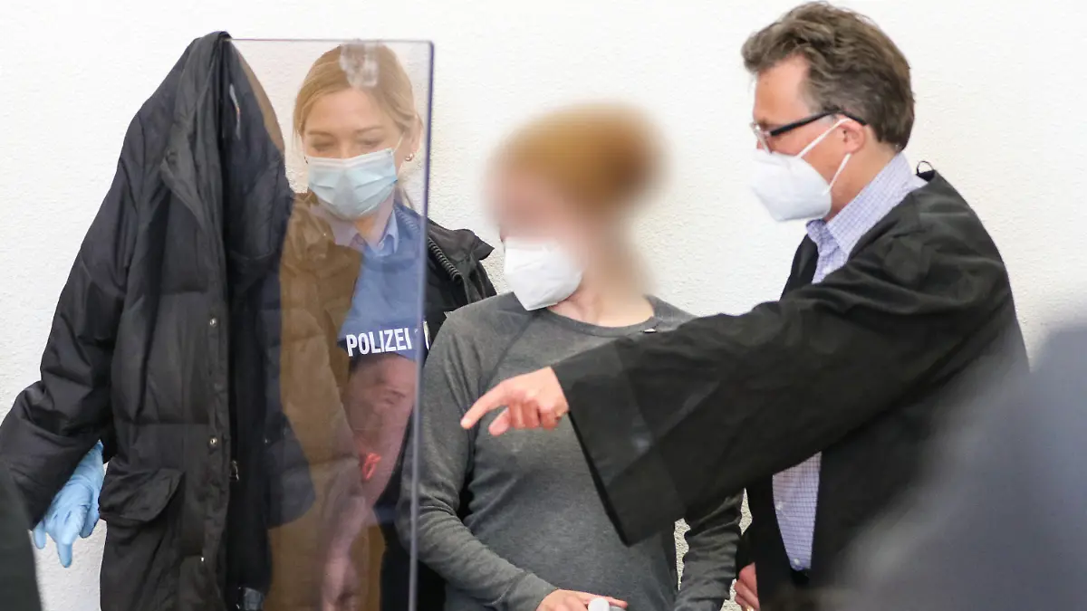 25.05.2021, Hessen, Alsfeld: Die Angeklagte (M) steht in einem Gerichtssaal im Landgericht und redet mit ihrem Anwalt Tronje Döhmer. Rund ein halbes Jahr nach den Protesten gegen den Weiterbau der Autobahn 49 im Dannenröder Forst in Mittelhessen hat am Dienstag der Prozess gegen die Frau begonnen. Sie soll in einem Protest-Camp einen Polizisten gegen den Kopf getreten haben und einem weiteren Beamten ihr Knie ins Gesicht gestoßen haben. (Zu dpa «Proteste zu Prozessbeginn gegen Aktivistin aus dem Dannenröder Forst») Foto: Nadine Weigel/dpa /dpa - ACHTUNG: Die Angeklagte wurde aus rechtlichen Gründen gepixelt +++ dpa-Bildfunk +++