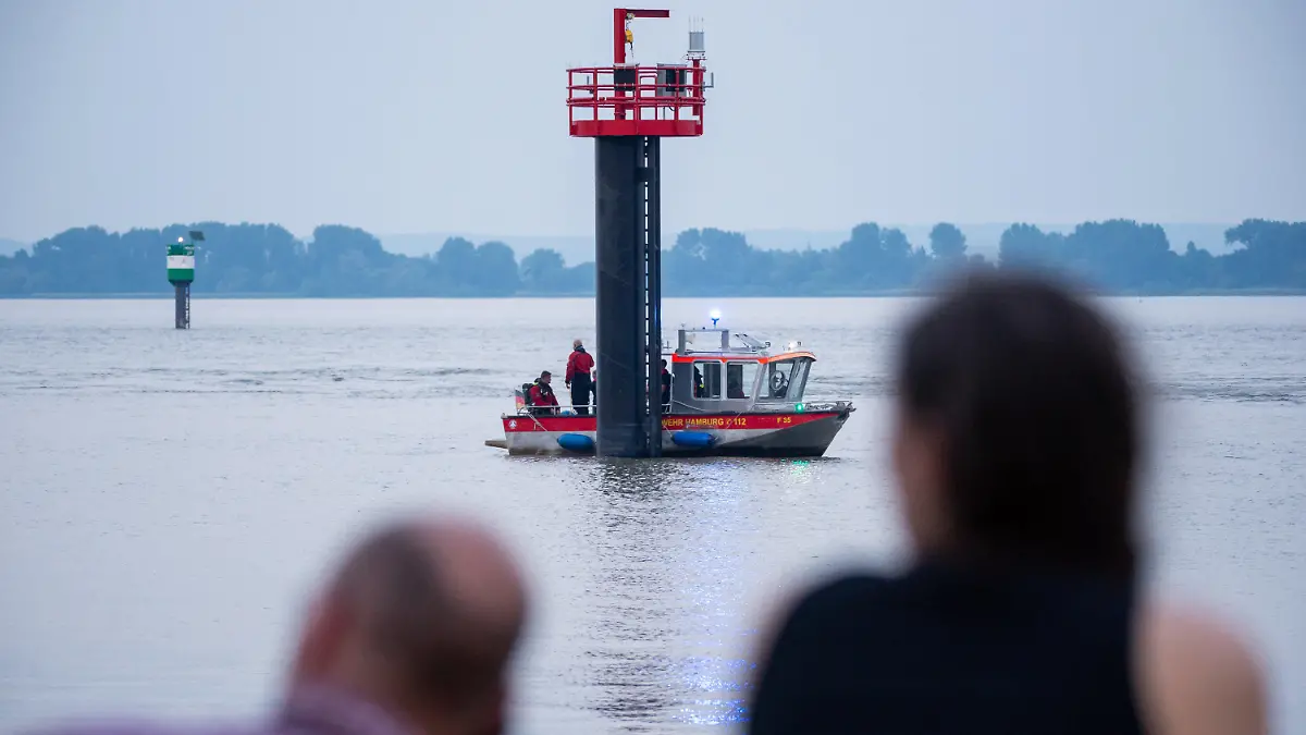 18.06.2021, Hamburg: Ein Kleinboot fährt auf der Elbe um den Signalturm. Feuerwehr und Polizei haben am Abend zweieinhalb Stunden nach einem jungen Mann gesucht, der von einem Signalturm in die Elbe gesprungen und nicht mehr aufgetaucht war. Sein Begleiter konnte laut Polizei aus dem Wasser gerettet werden. Foto: Jonas Walzberg/dpa +++ dpa-Bildfunk +++