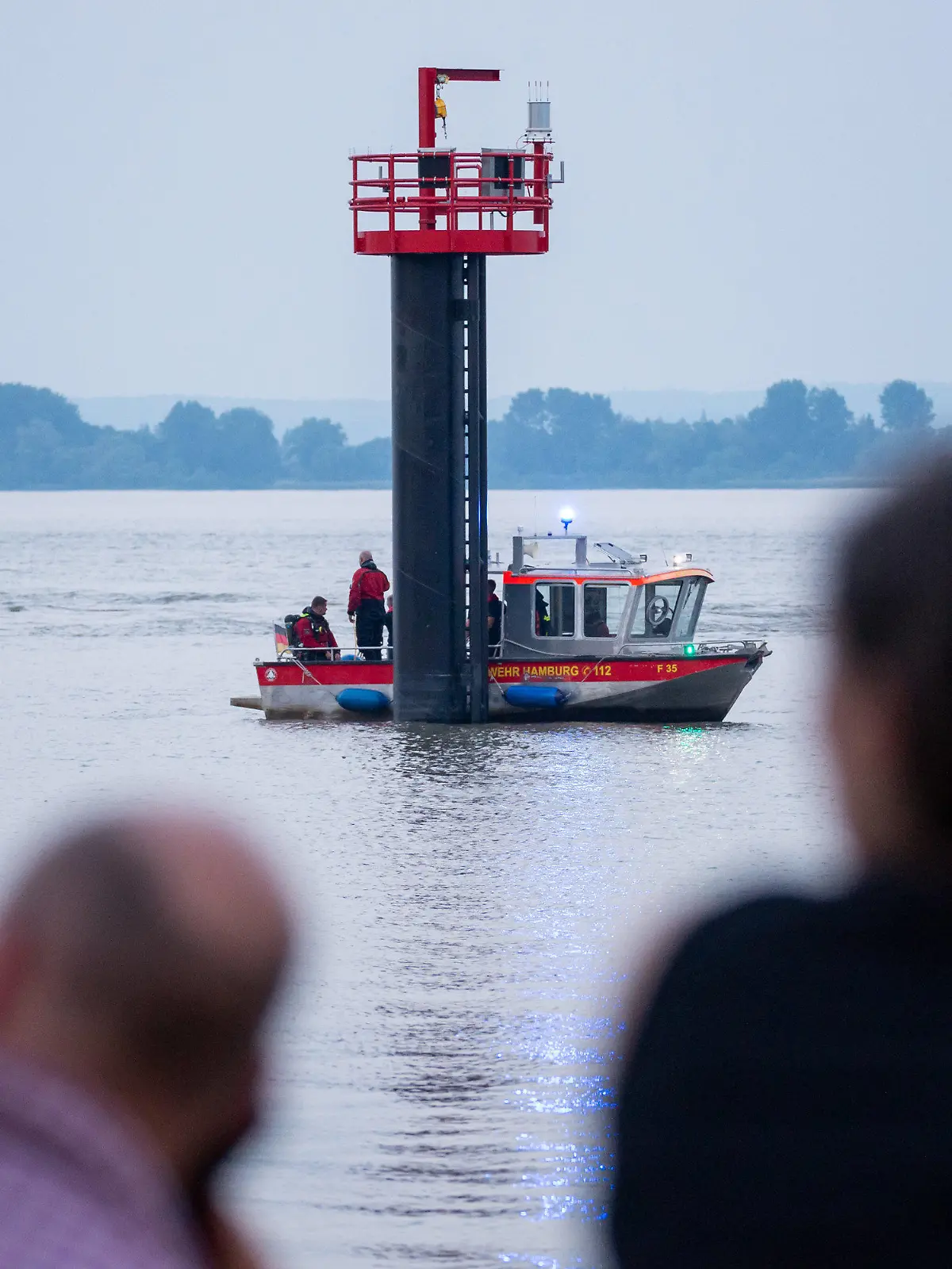 18.06.2021, Hamburg: Ein Kleinboot fährt auf der Elbe um den Signalturm. Feuerwehr und Polizei haben am Abend zweieinhalb Stunden nach einem jungen Mann gesucht, der von einem Signalturm in die Elbe gesprungen und nicht mehr aufgetaucht war. Sein Begleiter konnte laut Polizei aus dem Wasser gerettet werden. Foto: Jonas Walzberg/dpa +++ dpa-Bildfunk +++