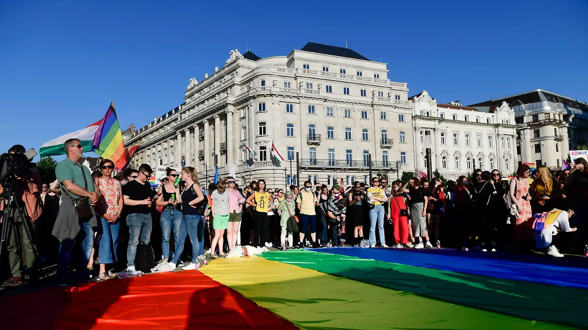 People unfurl a rainbow flag during an LGBT rights demonstration in front of the Hungarian Parliament building in Budapest, Hungary on June. 14, 2021. During the protest human rights activists called on lawmakers in Hungary to reject legislation banning any content portraying or promoting homosexuality or sex reassignment to anyone under 18. The bills, aiming at fighting pedophilia, have various amendments which would outlaw any depiction or discussion of different gender identities to youth in the public sphere.  (Szilard Koszticsak/MTI via AP)