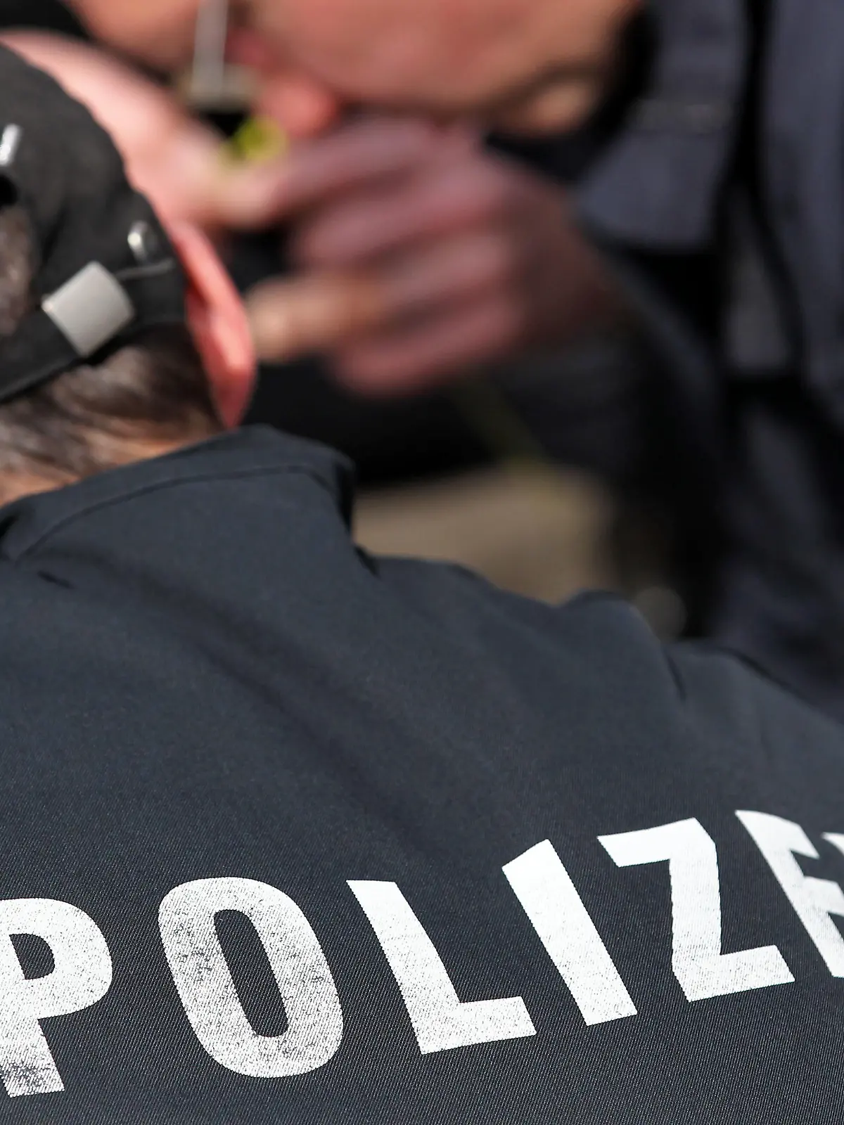 Der Schriftzug "Polizei" und das Logo von Thüringen stehen am Dienstag (10.04.2012) auf den Uniformen von zwei Polizeibeamten in Markkleeberg (Leipzig). Foto: Jan Woitas | Verwendung weltweit