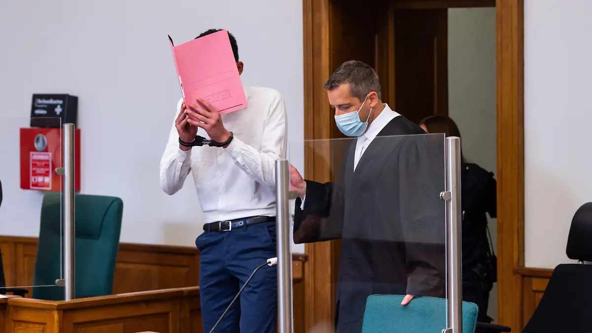 22.06.2021, Niedersachsen, Lüneburg: Der Angeklagte (l) wird von seinem Anwalt Moritz Klay (r) in den Saal vom Landgericht geführt. Der Angeklagte soll seine 19-jährige Freundin am 18. Januar 2021 in Lüneburg heimtückisch und aus niedrigen Beweggründen mit einem Messer getötet haben, weil er ihre Trennungsabsicht nicht akzeptieren konnte. Foto: Philipp Schulze/dpa +++ dpa-Bildfunk +++
