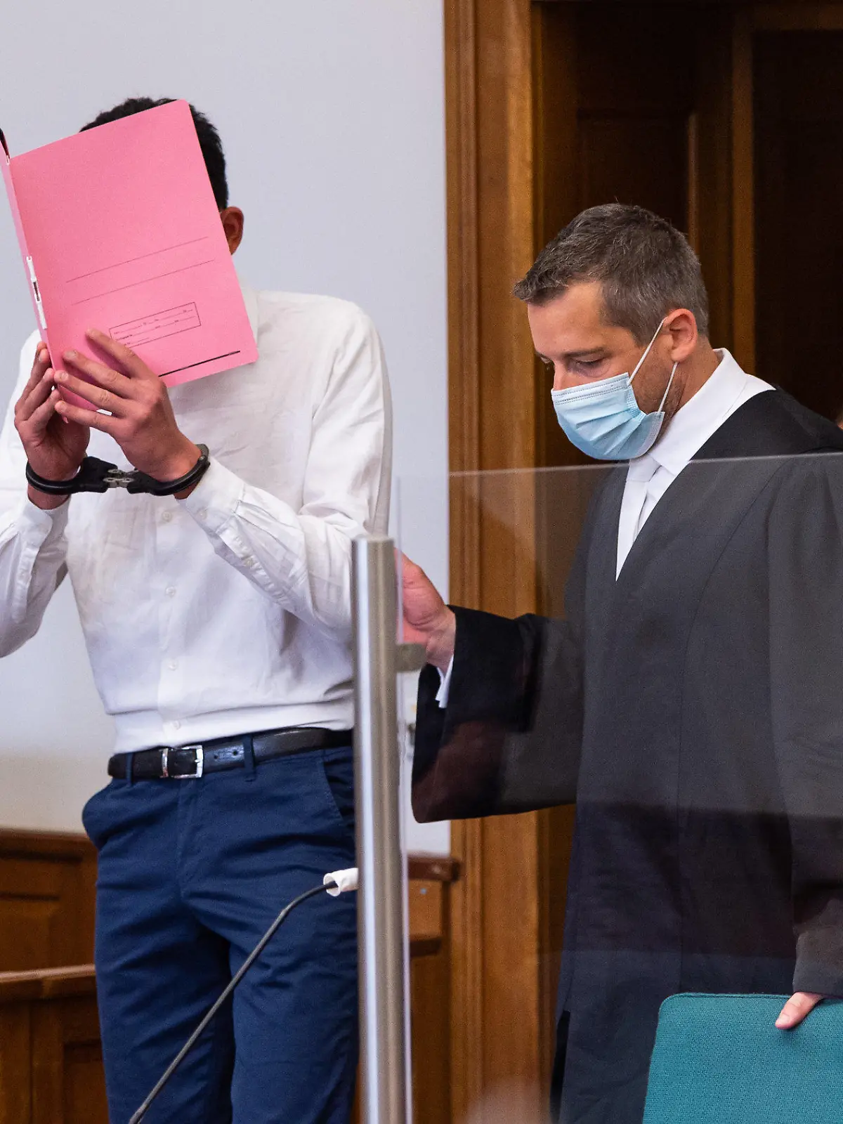 22.06.2021, Niedersachsen, Lüneburg: Der Angeklagte (l) wird von seinem Anwalt Moritz Klay (r) in den Saal vom Landgericht geführt. Der Angeklagte soll seine 19-jährige Freundin am 18. Januar 2021 in Lüneburg heimtückisch und aus niedrigen Beweggründen mit einem Messer getötet haben, weil er ihre Trennungsabsicht nicht akzeptieren konnte. Foto: Philipp Schulze/dpa +++ dpa-Bildfunk +++