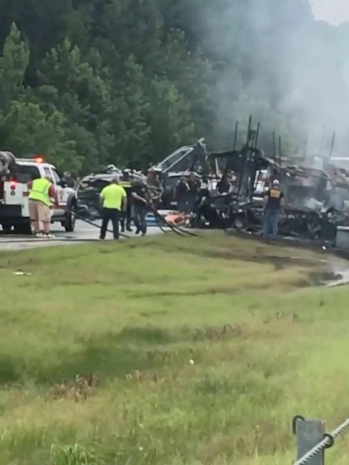 Emergency personnel work at the accident site as smoke rises from the wreckage after about 18 vehicles slammed together on a rain-drenched Alabama highway during Tropical Storm Claudette, in Butler County, Alabama, U.S., June 19, 2021, in this still image from video obtained via social media. RICKY SCOTT via REUTERS  ATTENTION EDITORS - THIS IMAGE HAS BEEN SUPPLIED BY A THIRD PARTY. NO RESALES. NO ARCHIVES. MANDATORY CREDIT.