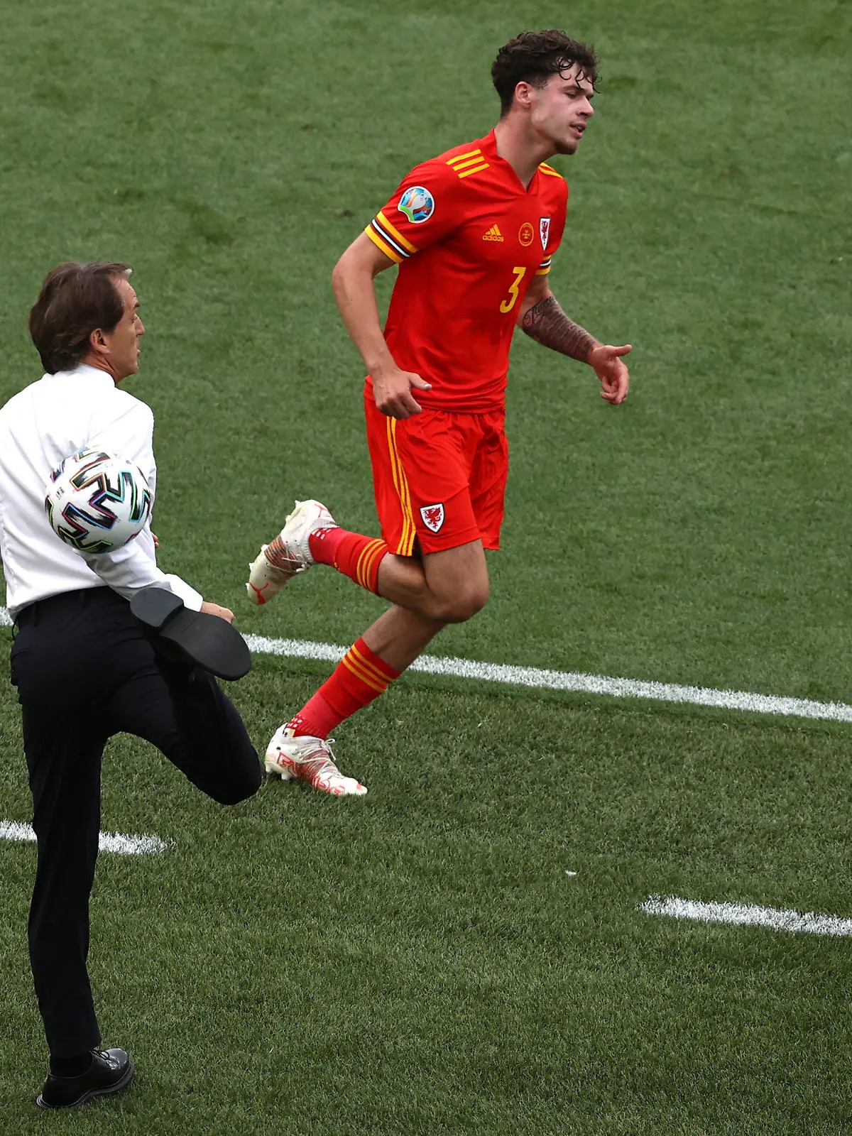 20.06.2021, Italien, Rome: Fußball, EM, Italien - Wales, Vorrunde, Gruppe A, 3. Spieltag, Stadio Olimpico di Roma: Italiens Trainer Roberto Mancini stoppt den Ball neben Wales' Neco Williams.     (zu dpa "Italien-Coach Mancini und der Hackentrick: «Er kann es noch!»") Foto: Ryan Pierse/Getty Pool/dpa +++ dpa-Bildfunk +++