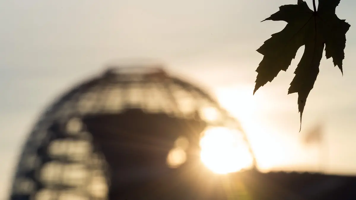 Ein welkes Blatt weht am Morgen des 01.11..2015 vor der Kulisse der Reichstagskuppel in Berlin. Foto: Soeren Stache/dpa +++(c) dpa - Bildfunk+++