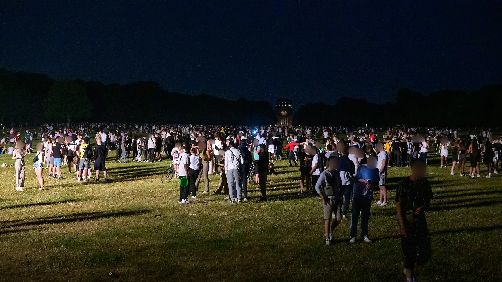 18.06.2021, Hamburg: Kleinere und größere Menschengruppen stehen auf der Stadtpark-Wiese im Schein des von der Polizei aufgestellten Lichtmastes. Die Polizei hat eine Party mit rund 3000 Menschen im Hamburger Stadtpark aufgelöst. (zu dpa: «Polizei räumt Party von 3000 Menschen im Hamburger Stadtpark») Foto: Jonas Walzberg/dpa - ACHTUNG: Person(en) wurde(n) aus rechtlichen Gründen gepixelt +++ dpa-Bildfunk +++