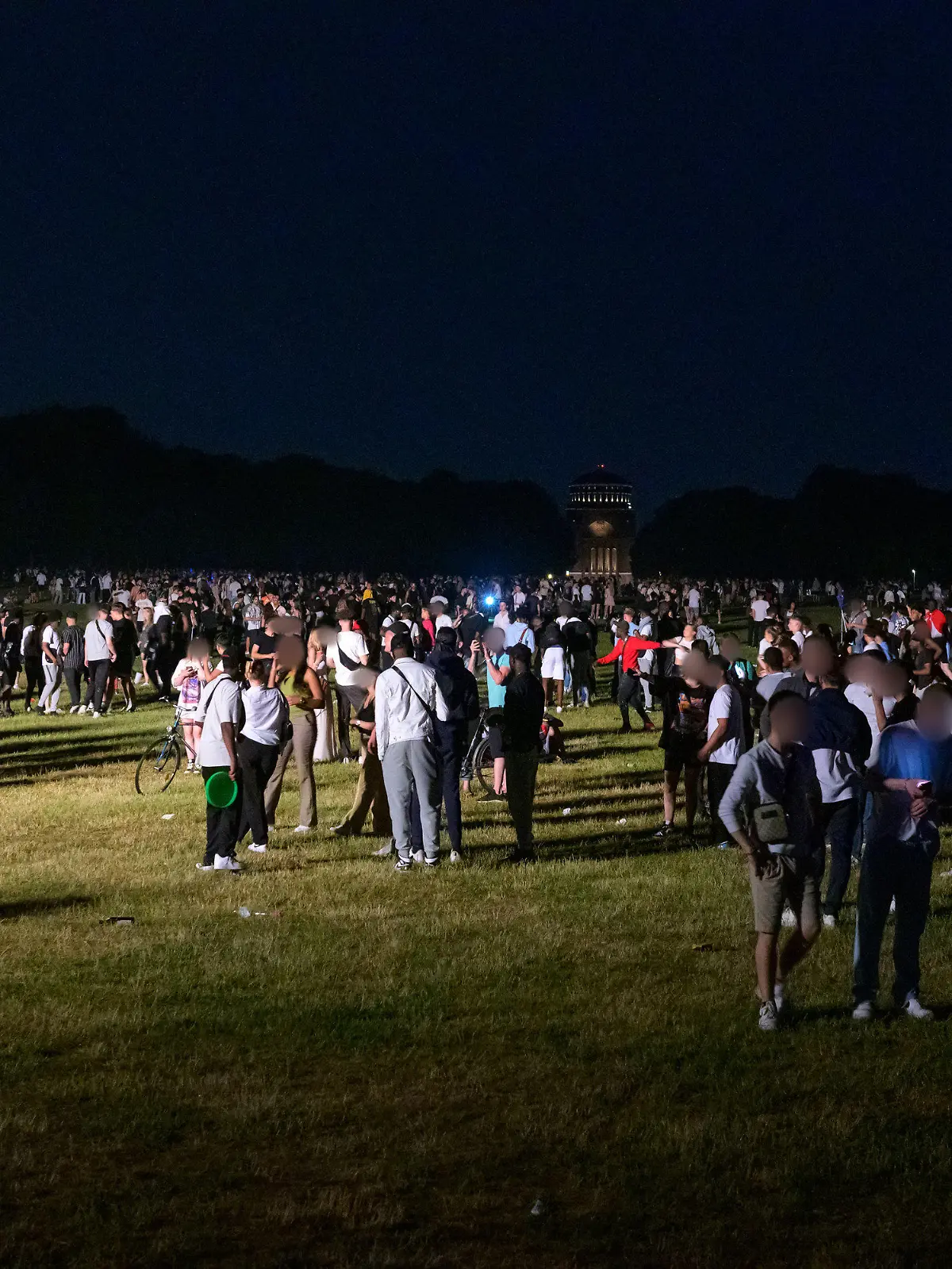 18.06.2021, Hamburg: Kleinere und größere Menschengruppen stehen auf der Stadtpark-Wiese im Schein des von der Polizei aufgestellten Lichtmastes. Die Polizei hat eine Party mit rund 3000 Menschen im Hamburger Stadtpark aufgelöst. (zu dpa: «Polizei räumt Party von 3000 Menschen im Hamburger Stadtpark») Foto: Jonas Walzberg/dpa - ACHTUNG: Person(en) wurde(n) aus rechtlichen Gründen gepixelt +++ dpa-Bildfunk +++