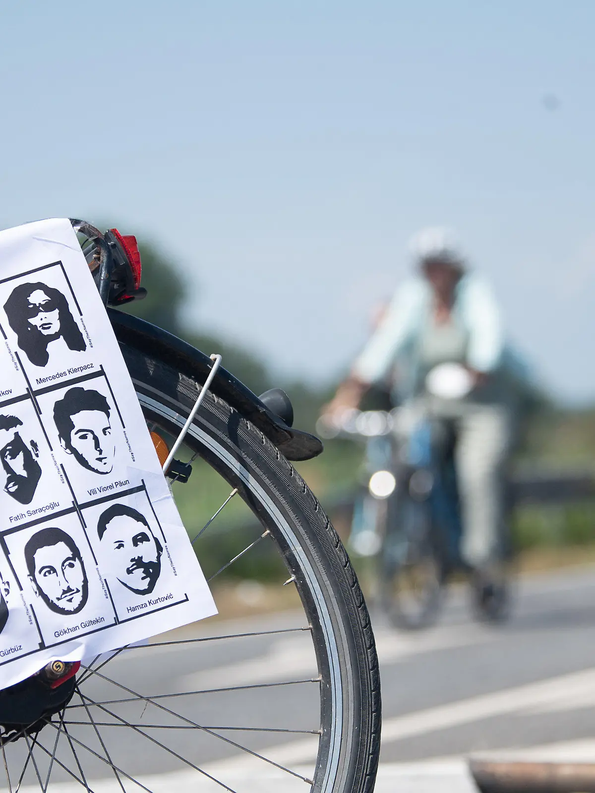 19.06.2021, Hessen, Maintal: Ein Fahrrad mit dem Konterfei der Opfer steht während der Fahrradsternfahrt «Stern für Hanau» zur Erinnerung an den rechtsterroristischen Anschlag vor den Teilnehmenden. An dem «Ride to Remember» beteiligen sich Radfahrer aus vielen Gemeinden und Städten Hessens sowie aus Nordbayern. Foto: Sebastian Gollnow/dpa +++ dpa-Bildfunk +++