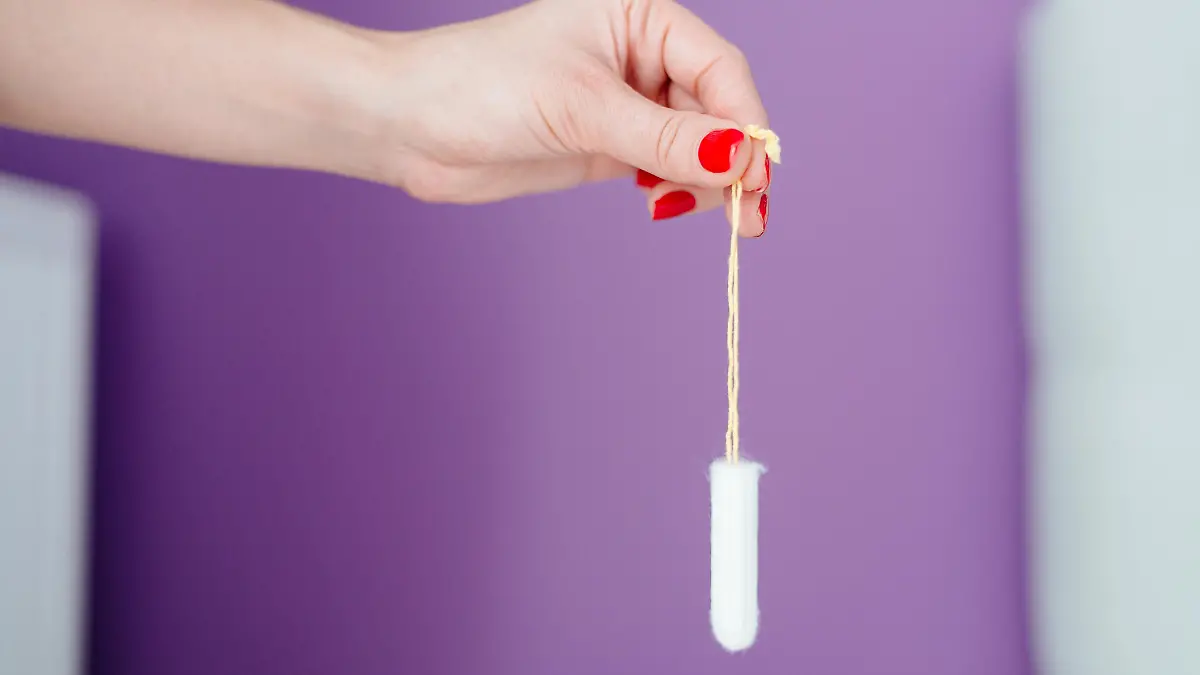 Frau hält Tampon in der Hand.