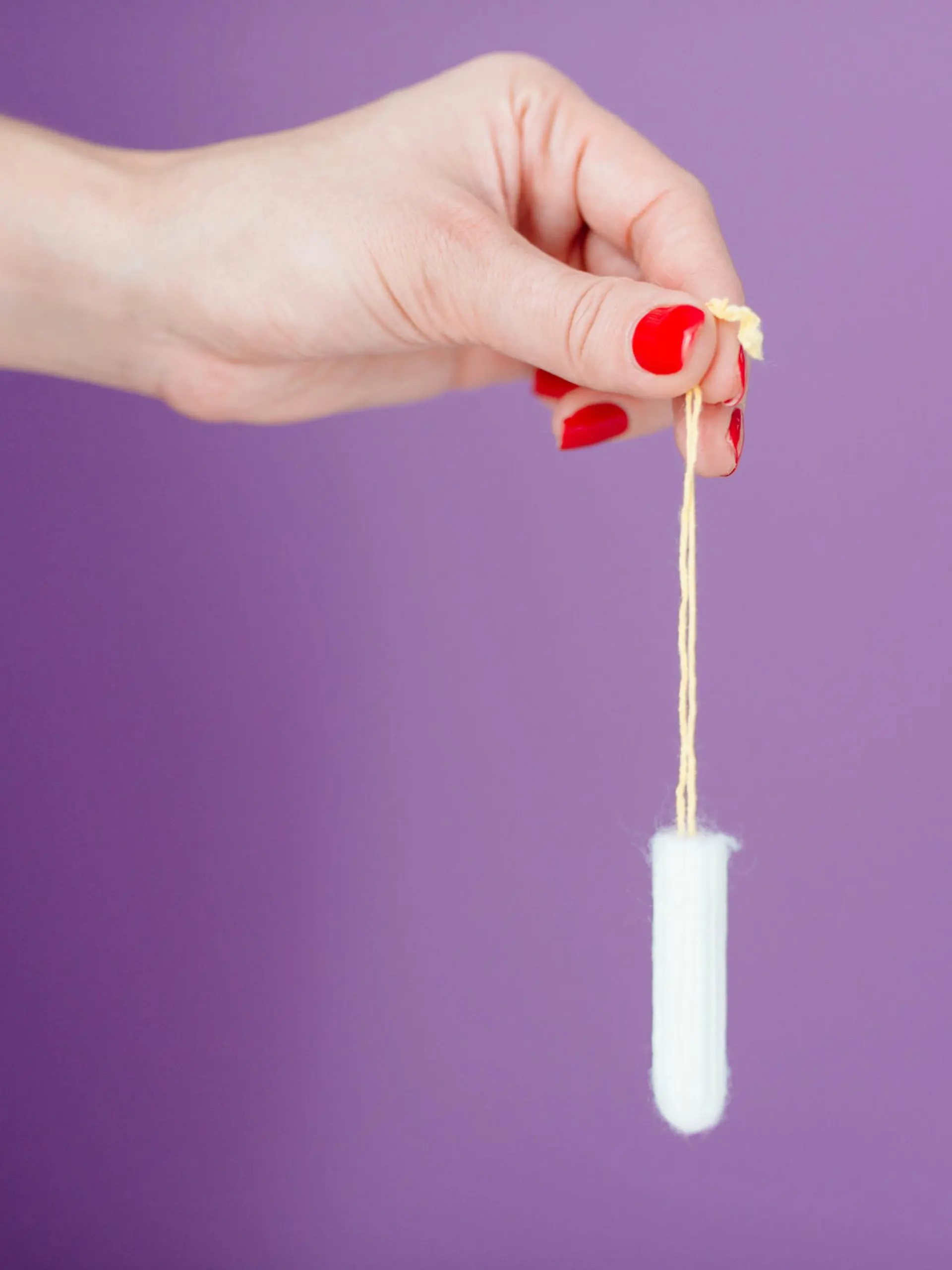 Frau hält Tampon in der Hand.
