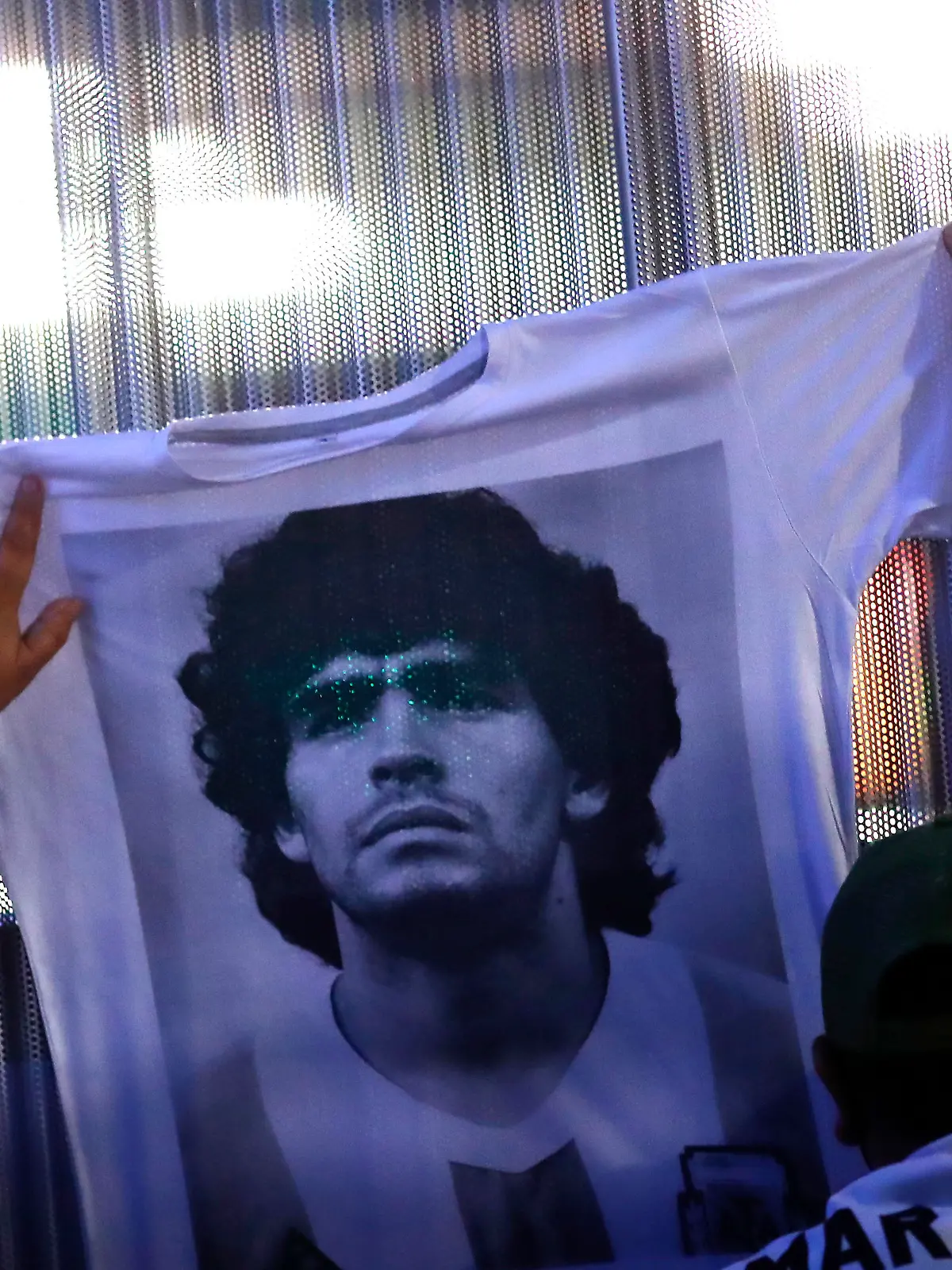 OLIVOS, ARGENTINA - NOVEMBER 03: Fans hold a jersey with the face of Diego Maradona at Clínica Olivos on November 03, 2020 in Olivos, Argentina. Personal doctor of Maradona, Leopoldo Luque, confirmed the former footballer will under a surgery to treat a clot in his brain. Maradona, who turned 60 on Friday 30, had spent the night of Monday hospitalized after being admitted with symptoms of depression. (Photo by Marcos Brindicci/Getty Images)
