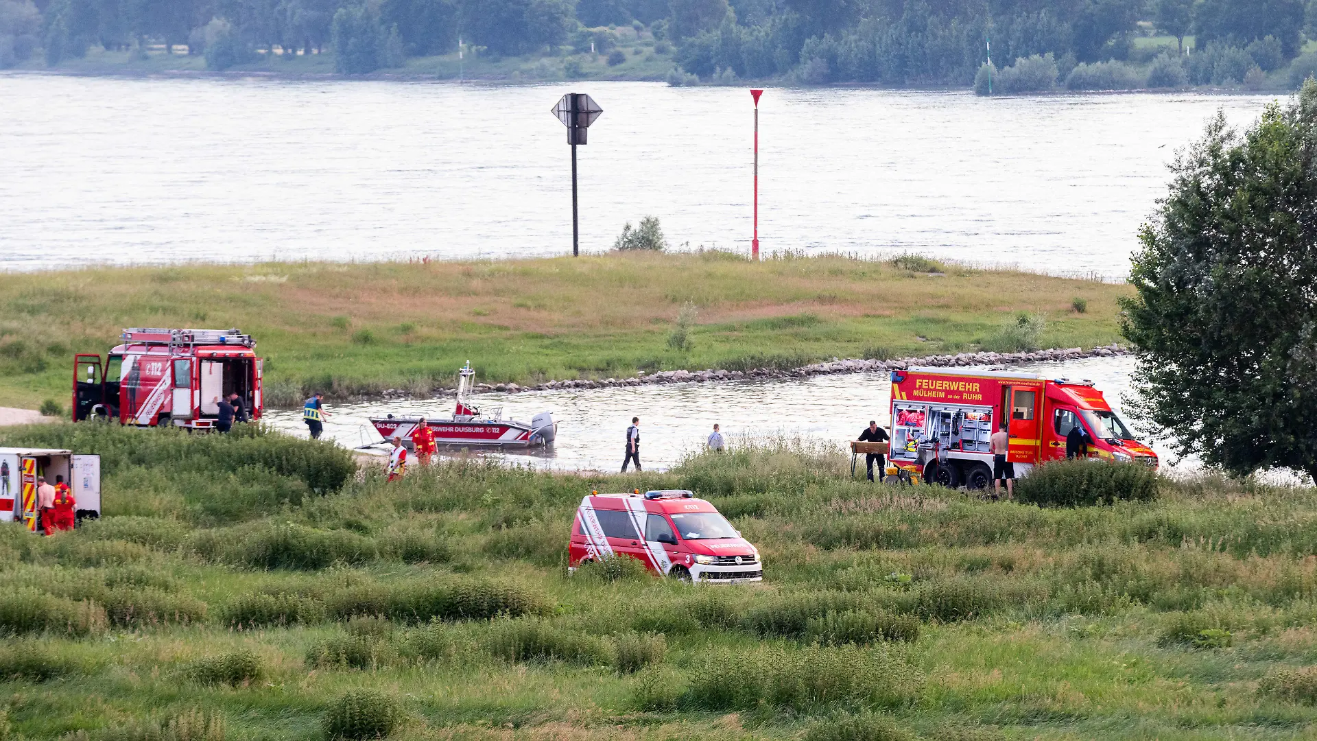 16.06.2021, Nordrhein-Westfalen, Duisburg: Einsatzkräfte der Polizei, Feuerwehr und DRLG arbeiten am Ufer des Rheins. Nach einem möglichen Badeunfall ist eine Person gerettet worden. Zwei weitere werden noch vermisst. Foto: Marcel Kusch/dpa +++ dpa-Bildfunk +++