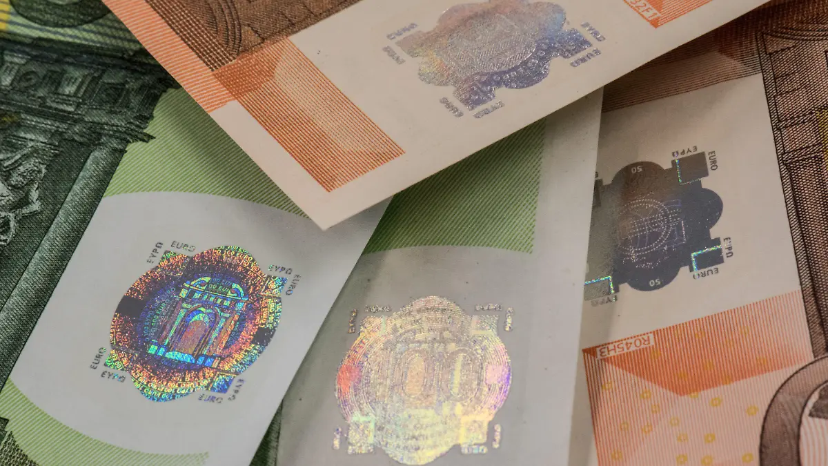 SPERRFRIST 23.01.15 / 10.15 Uhr !!! Eine gefälschter 100-Euro-Schein (Mitte) liegt am 21.01.2015 in einem Raum der Bundesbank in Frankfurt am Main (Hessen) neben anderen gefälschten Geldscheinen und ist dabei vor allem durch sein nachgemachtes Hologramm zu erkennen. Im Euro-Raum wurde im vergangenen Jahr wieder Falschgeld in Millionenhöhe sichergestellt. Foto: Boris Roessler/dpa (Zu dpa-lhe "Falschgeld-Aufkommen massiv gestiegen" vom 23.01.2015) +++(c) dpa - Bildfunk+++