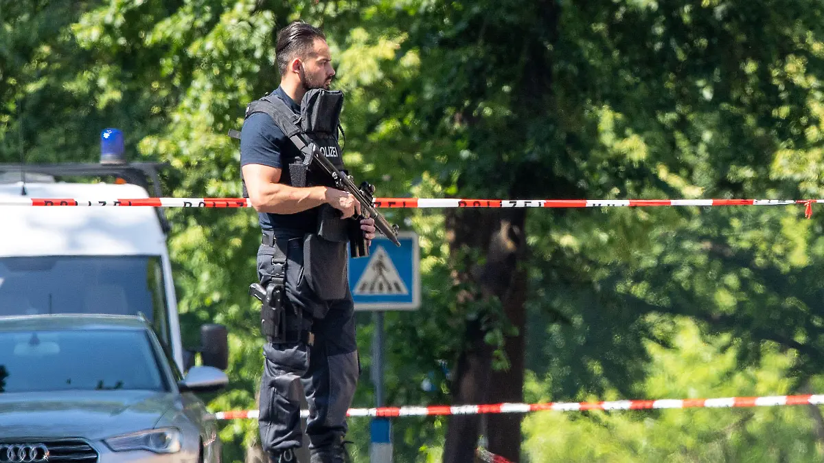 17.06.2021, Nordrhein-Westfalen, Espelkamp: Ein Polizist mit Schutzweste und Gewehr steht an einer Absperrung in Espelkamp. In Espelkamp sind nach Angaben der Bielefelder Polizei zwei Menschen erschossen worden. Der Täter befinde sich noch auf der Flucht, sagte ein Polizeisprecher der Deutschen Presse-Agentur am Donnerstag. Foto: Lino Mirgeler/dpa +++ dpa-Bildfunk +++