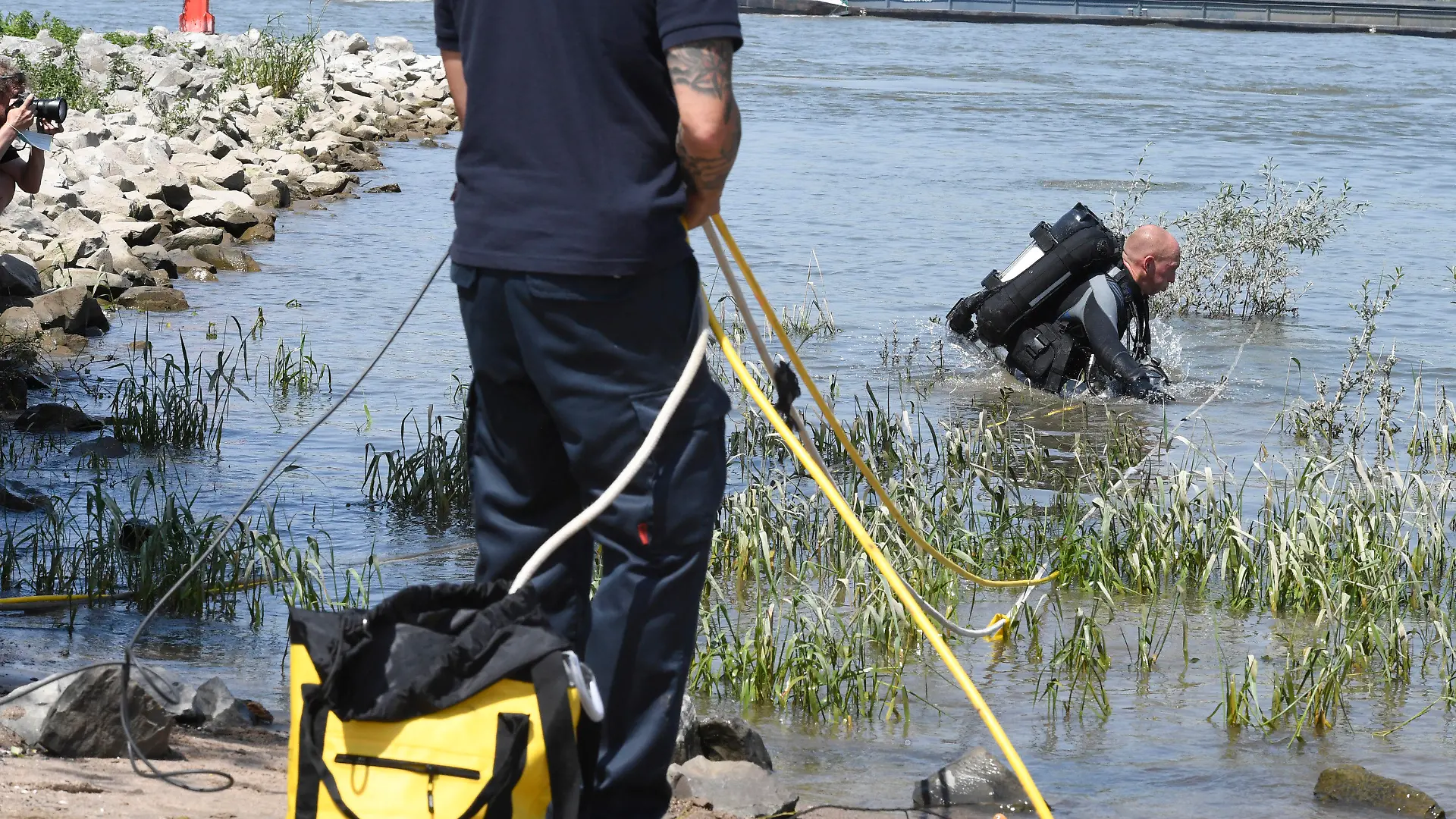 17.06.2021, Nordrhein-Westfalen, Duisburg: Einsatzkräfte der Feuerwehr und Polizei intensivieren mittels Tauchern, Hubschraubern und Rettungsbooten, die Suche nach zwei vermissten Mädchen, die am Mittwochabend im Fluss ein erfrischendes Bad nehmen wollten. Beim Baden im Rhein ist am Mittwochabend in Duisburg eine 17-Jährige ertrunken. Nach zwei Mädchen, die zusammen mit der 17-Jährigen ins Wasser gegangenen waren, suchte die Polizei am Donnerstagmorgen noch mit Rettungsbooten und Hubschraubern, wie eine Sprecherin mitteilte. Foto: Roberto Pfeil/dpa +++ dpa-Bildfunk +++