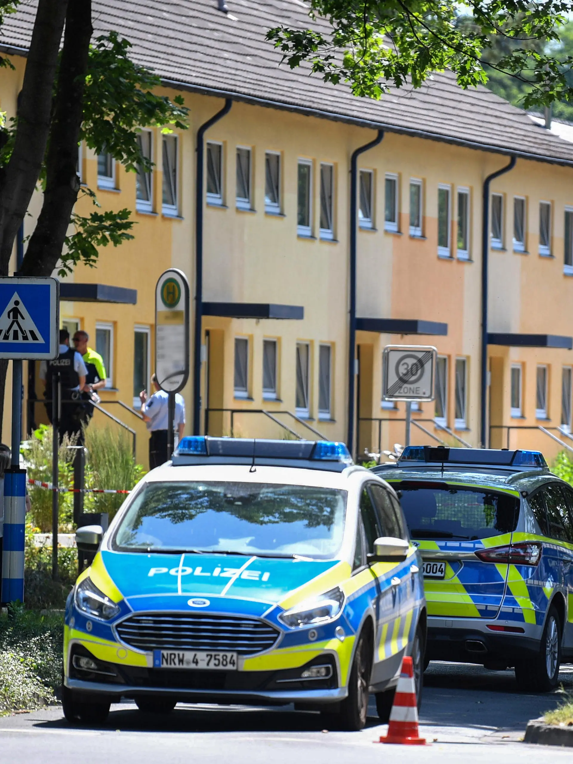 dpatopbilder - 17.06.2021, Nordrhein-Westfalen, Espelkamp: Polizeibeamte stehen vor einem Haus. In Espelkamp sind nach Angaben der Bielefelder Polizei zwei Menschen erschossen worden. Der Täter befinde sich noch auf der Flucht, sagte ein Polizeisprecher der Deutschen Presse-Agentur am Donnerstag. Important: For editorial news reporting purposes only. Not used for commercial or marketing purposes without prior written approval of UEFA. Images must appear as still images and must not emulate match action video footage. Photographs published in online publications (whether via the Internet or otherwise) shall have an interval of at least 20 seconds between the posting. Foto: Lino Mirgeler/dpa +++ dpa-Bildfunk +++